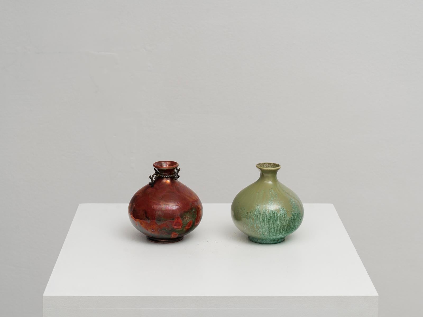 Pair of small vases by Italian ceramic master Guido Andloviz for S.C.I. Laveno. The model is Monza 30, documented and published. Made of glazed earthenware, both in excellent original conditions with no restorations. The one with the red metallic