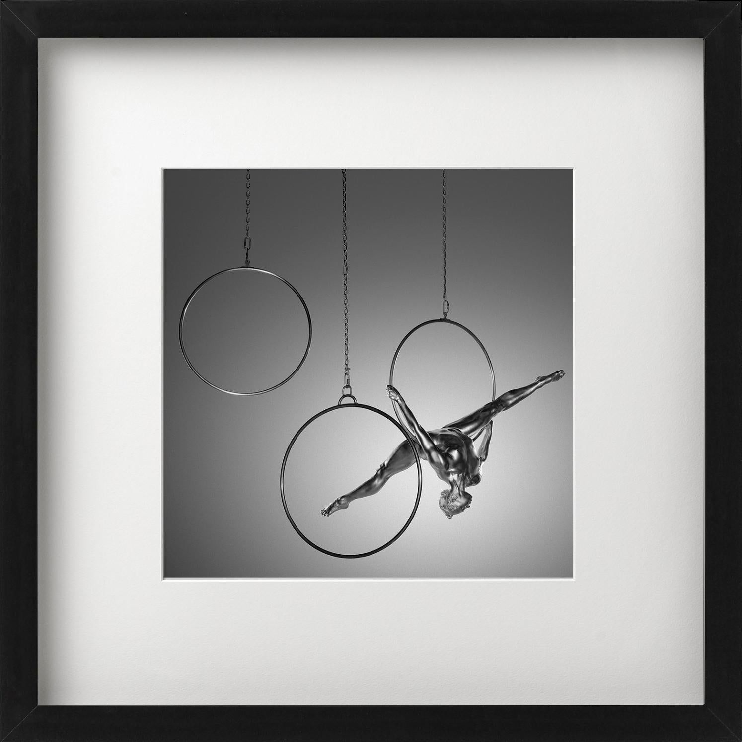 'EIRENE' depicts a nude model covered in silver paint in a acrobatic pose hanging from a Hoop, photographed by Guido Argentini as Part of his Silver Series.

All prints are limited edition. Available in multiple sizes. High-end framing on