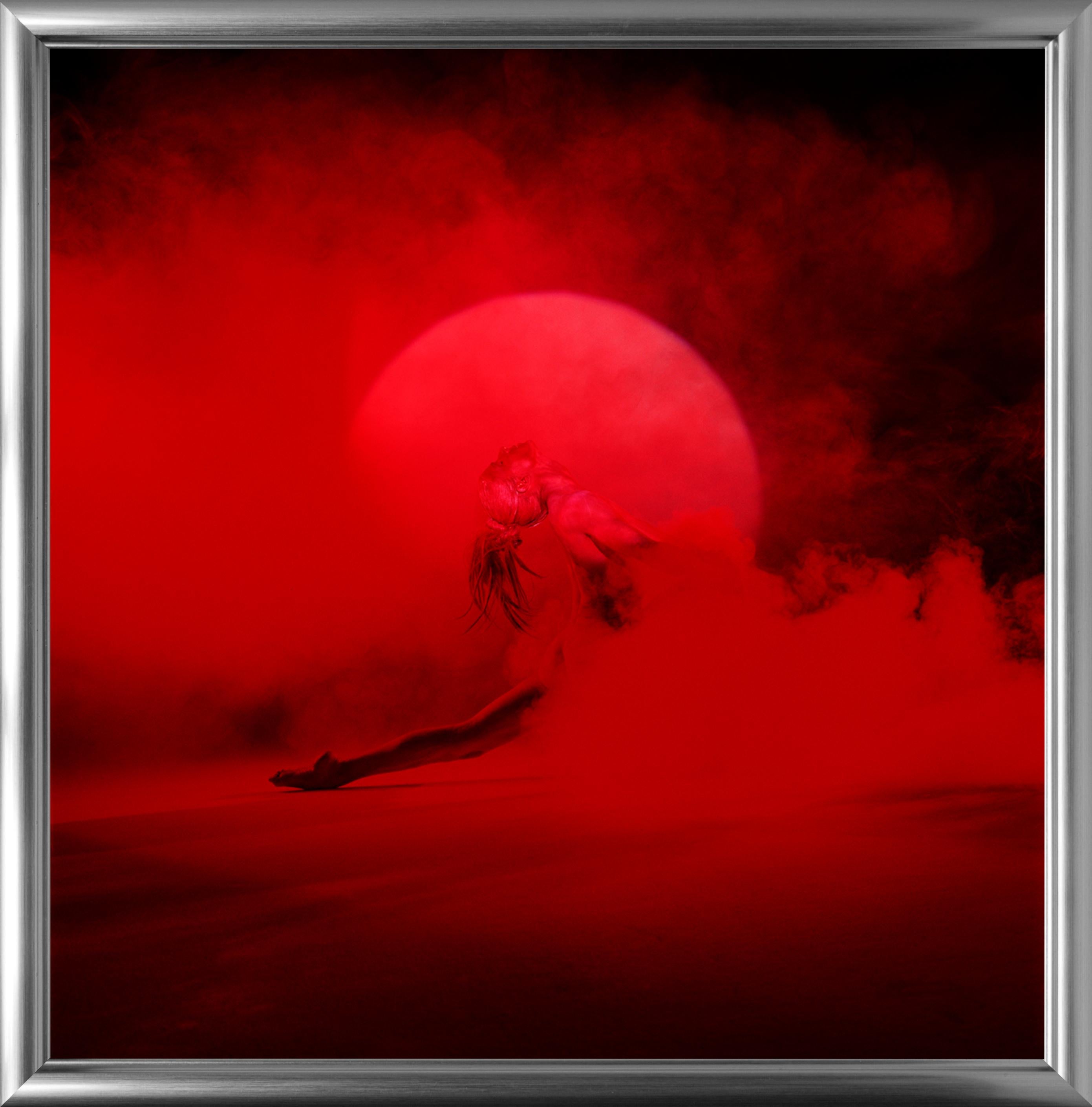 Giulia and Red Smoke - nude photograph of female model with red background - Photograph by Guido Argentini