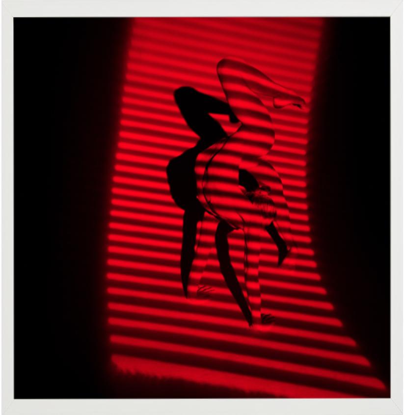 Giulia and Red Stripes - nude photograph of female model with red background - Black Nude Photograph by Guido Argentini