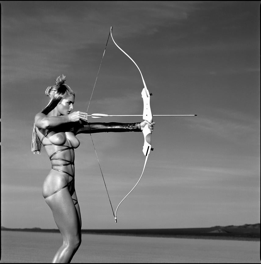 Olympic Archery- nude model holding a bow in her hands