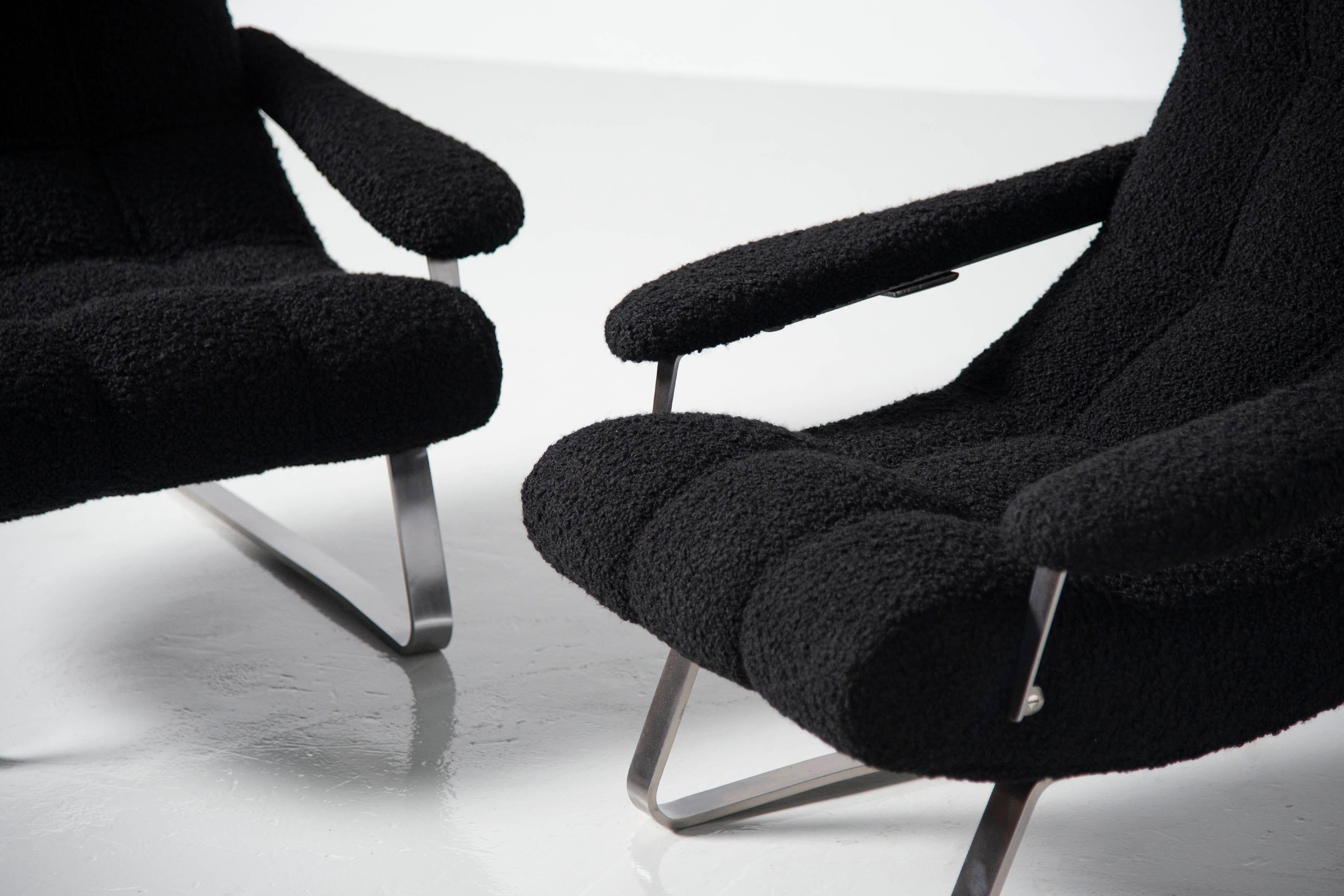 Large pair of lounge chairs designed by Guido Bonzano and manufactured by Tecnosalotto, Italy 1970. These chairs have spring steel feet which bring extra comfort when seating on them. They are upholstered in a beautiful black bouclé fabric and look