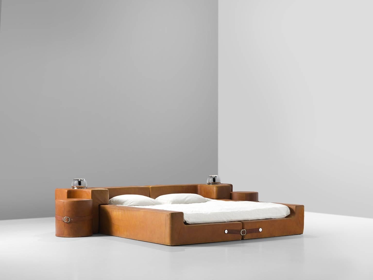 Guido Faleschini for Mariani, bed in cognac leather, chrome-plated brass, enameled steel, chrome, Italy, circa 1975.

This Italian bed includes bedframe with headboard, two nightstands and two build in night lights. True example of playful