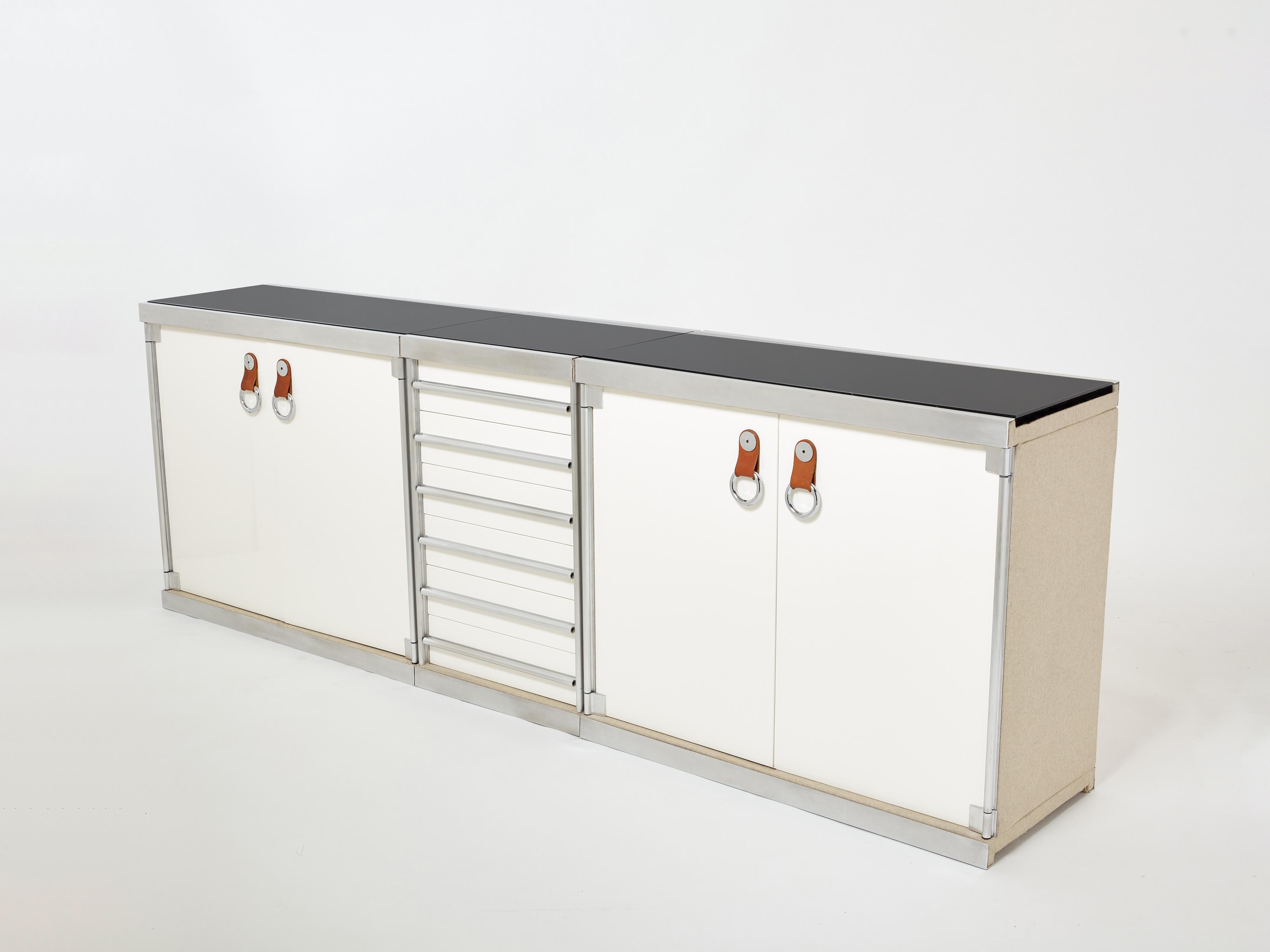Beautiful set of three cabinets forming a large sideboard designed by Guido Faleschini and produced by I4 Mariani in Italy for Hermès boutiques in the 1970s. This set presents two cabinets with off white lacquered doors with Hermès tan leather