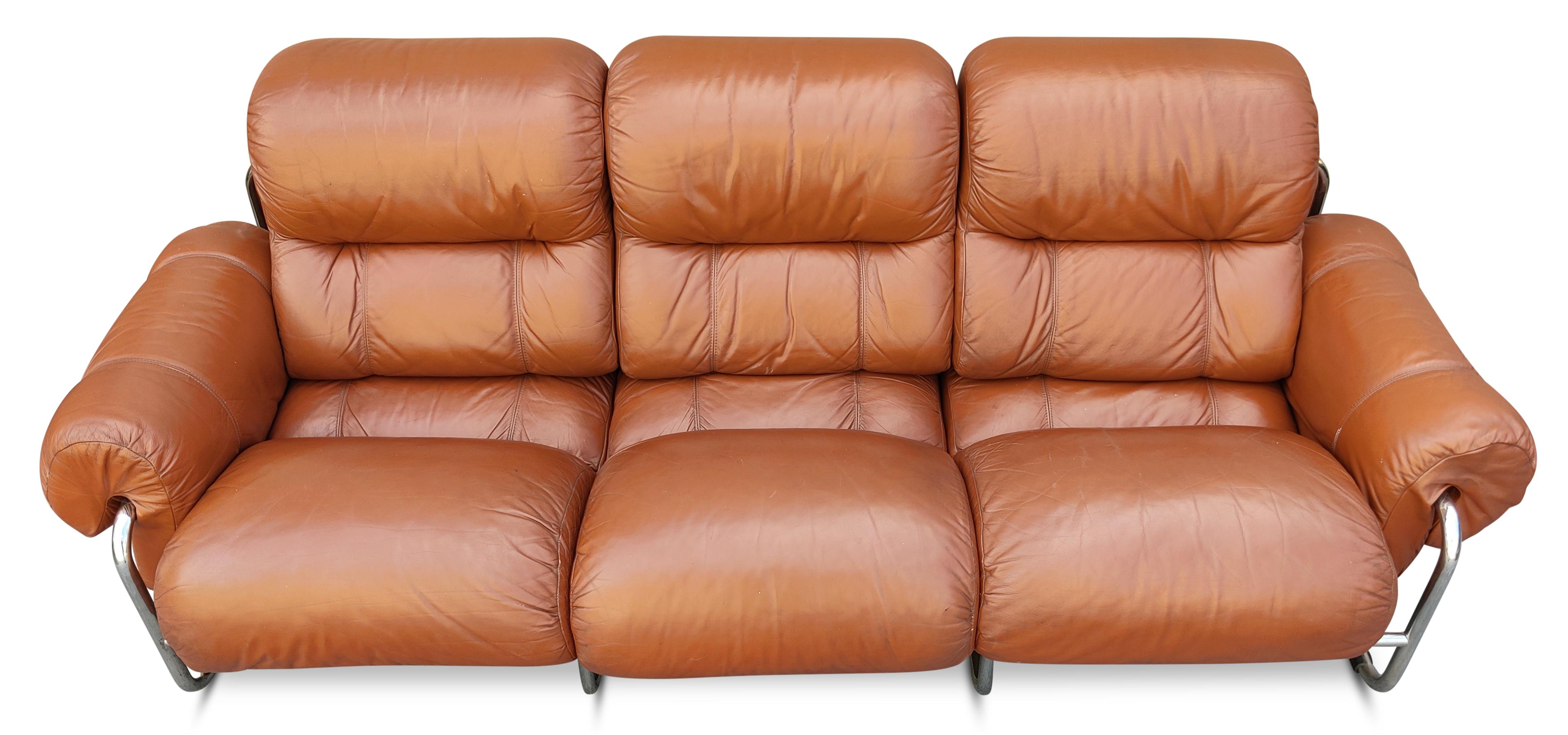 A rare 3-seat sofa with arm with arms was created in the 1970s by Guido Faleschini for i4 Mariani, a subsidiary design firm for the esteemed manufacturer Pace Furniture Company. Our example features its original cognac colored quality leather