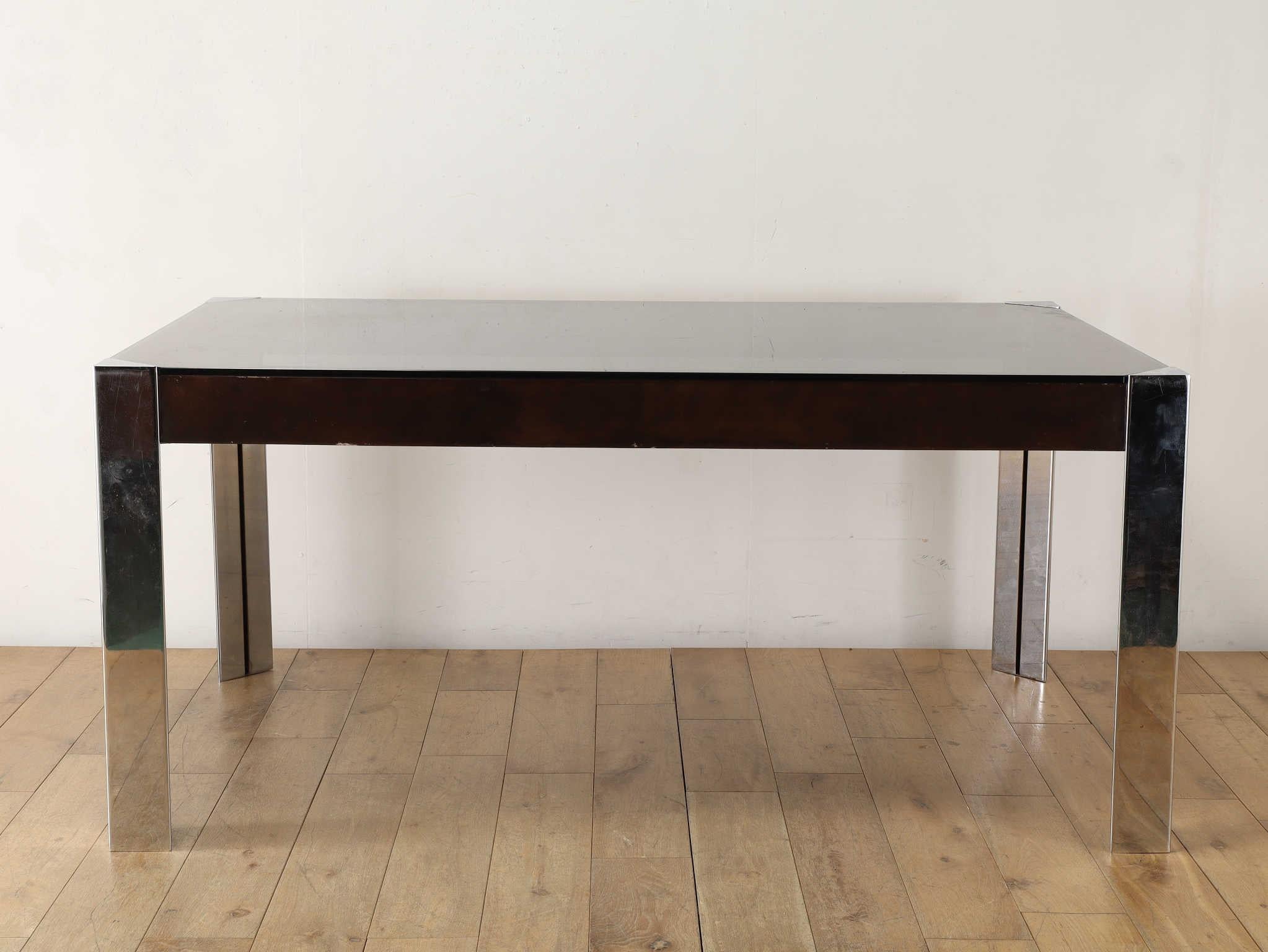 This elegant glass-top table was designed by renowned Italian designer Guido Faleschini, known for his sophisticated approach to modern furniture design.
Combining sleek chrome with crisp glass, the table embraces a minimalist, industrial aesthetic