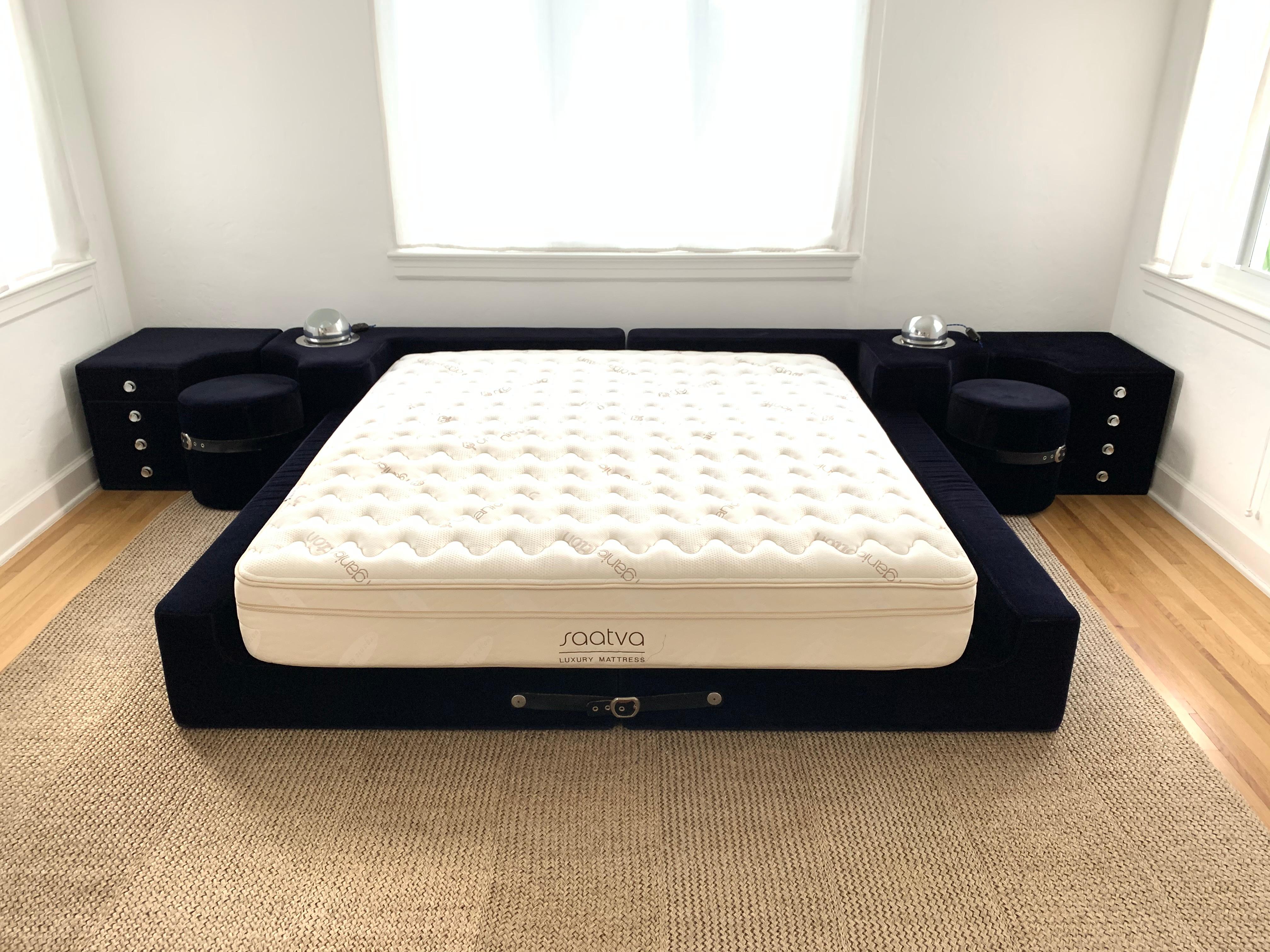 Ink colored (blue-black) velvet king size bed designed by Guido Faleschini and manufactured by i4 Mariani exclusively for the Pace Collection, with black leather straps and chrome buckles, integrated nightstands, ottomans, and lights.
