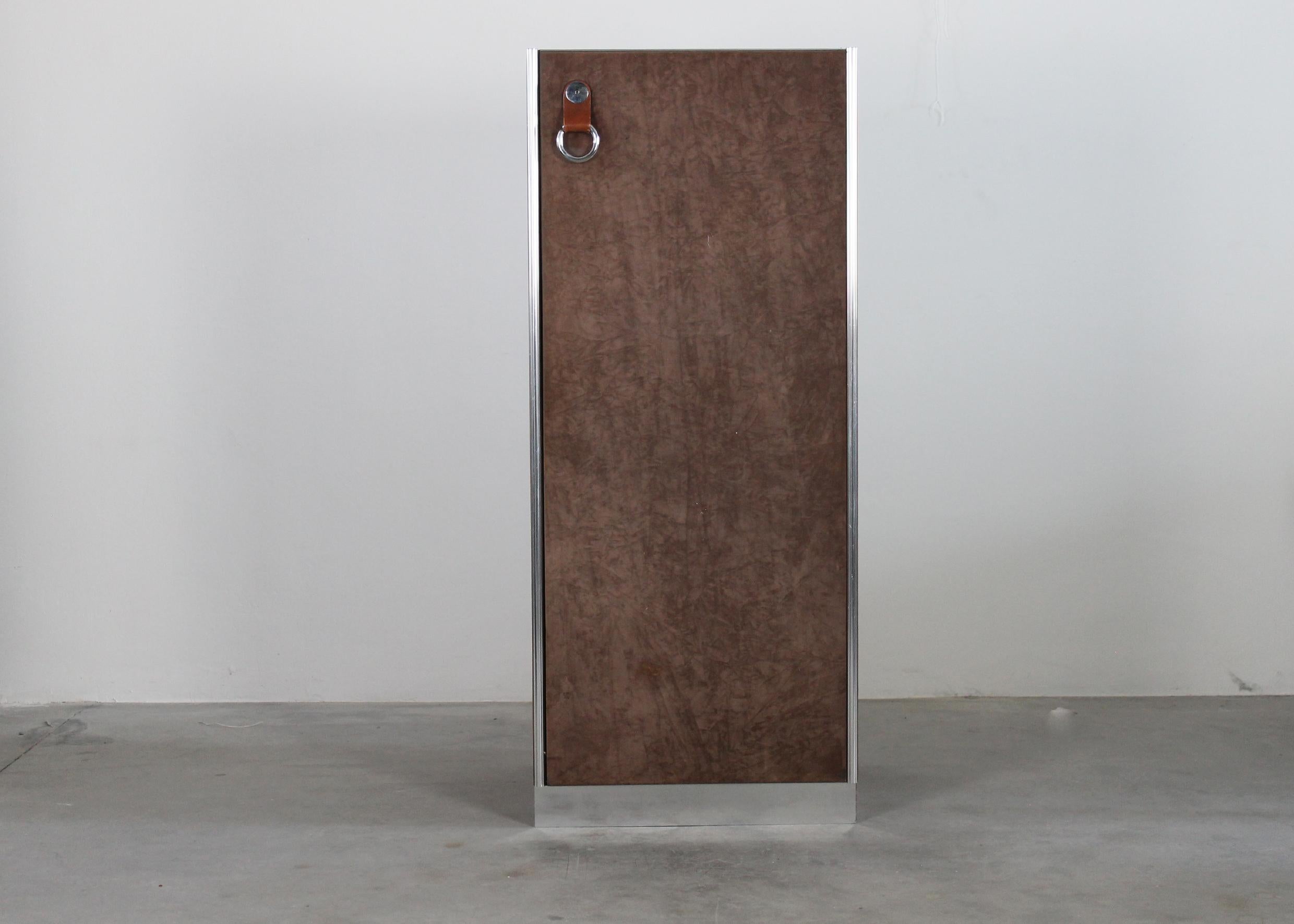Wardrobe with suede clad panels, each panel is surrounded by a chromed steel frame and presents metal ring shape handles on the frontal part.

This cabinet was designed by Guido Faleschini as part of the Pace Collection for Italian furniture company