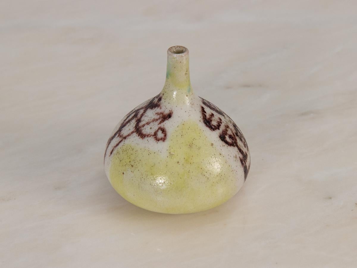 Rustic bud vase by master ceramicist Guido Gambone. Hand-thrown in an alluring organic shape with an elongated neck. The vase depicts a pastoral scene of a shepherd with his herd painted freehand, with a wash of citron yellow in the background. The