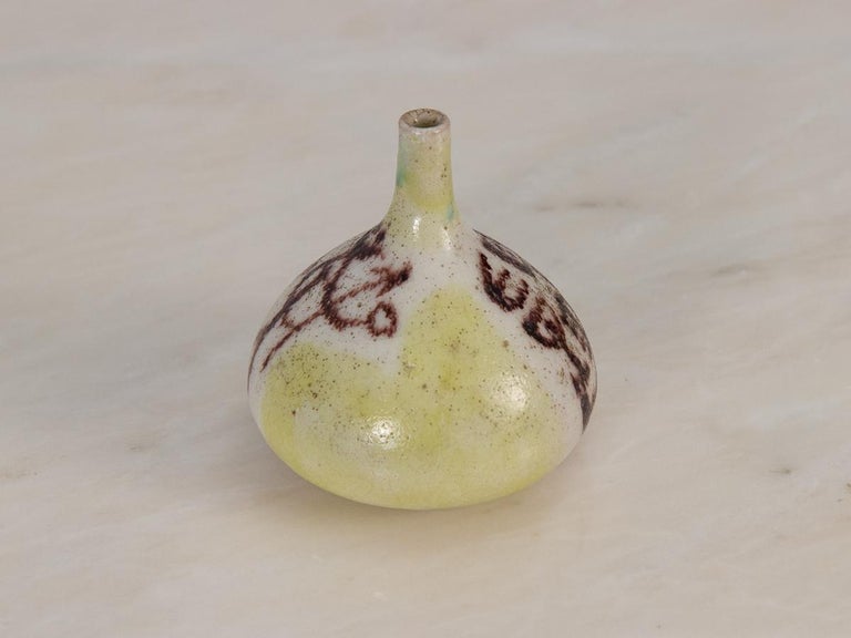 Rustic bud vase by master ceramicist Guido Gambone. Hand-thrown in an alluring organic shape with an elongated neck. The vase depicts a pastoral scene of a shepherd with his herd painted freehand, with a wash of citron yellow in the background. The