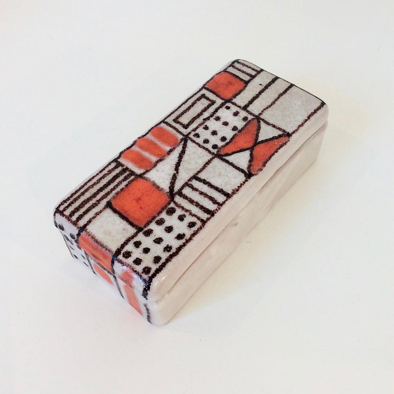 Very nice Guido Gambone rectangular box, circa 1950, Italy.
Abstract hand painted decor in red-orange and black on white glazed ceramic.
Signed Gambone, Italy with donkey mark.
Dimensions: 19 cm W, 9 cm D, 6 cm H.
Good original condition.
All