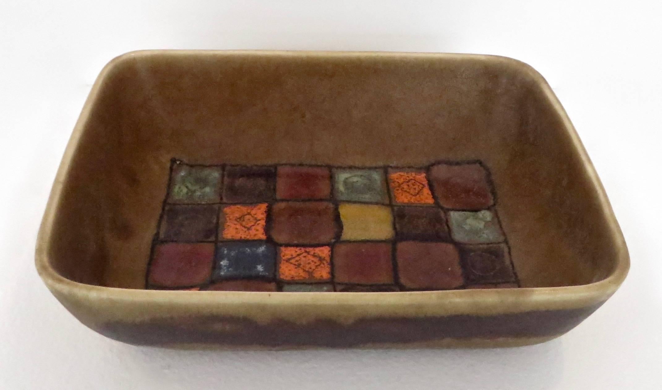 Very unusual Guido Gambone polychrome rectangular ceramic Italian dish.
An interesting and vibrant palette of colors in ochre background and detailed interior. The grid of brown, orange and blue is quite unusual for Gambone.
The exterior color is