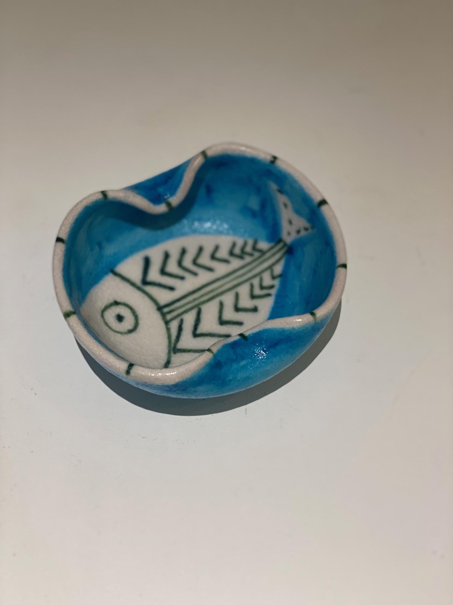 Guido Gambone (1909-1969)
Fish hand painted decor on blue glazed ceramic small cup .
Signed Gambone, Italy with donkey mark.
Guido Gambone was one of the best known leaders of the Italian midcentury modernist ceramics movement.
 