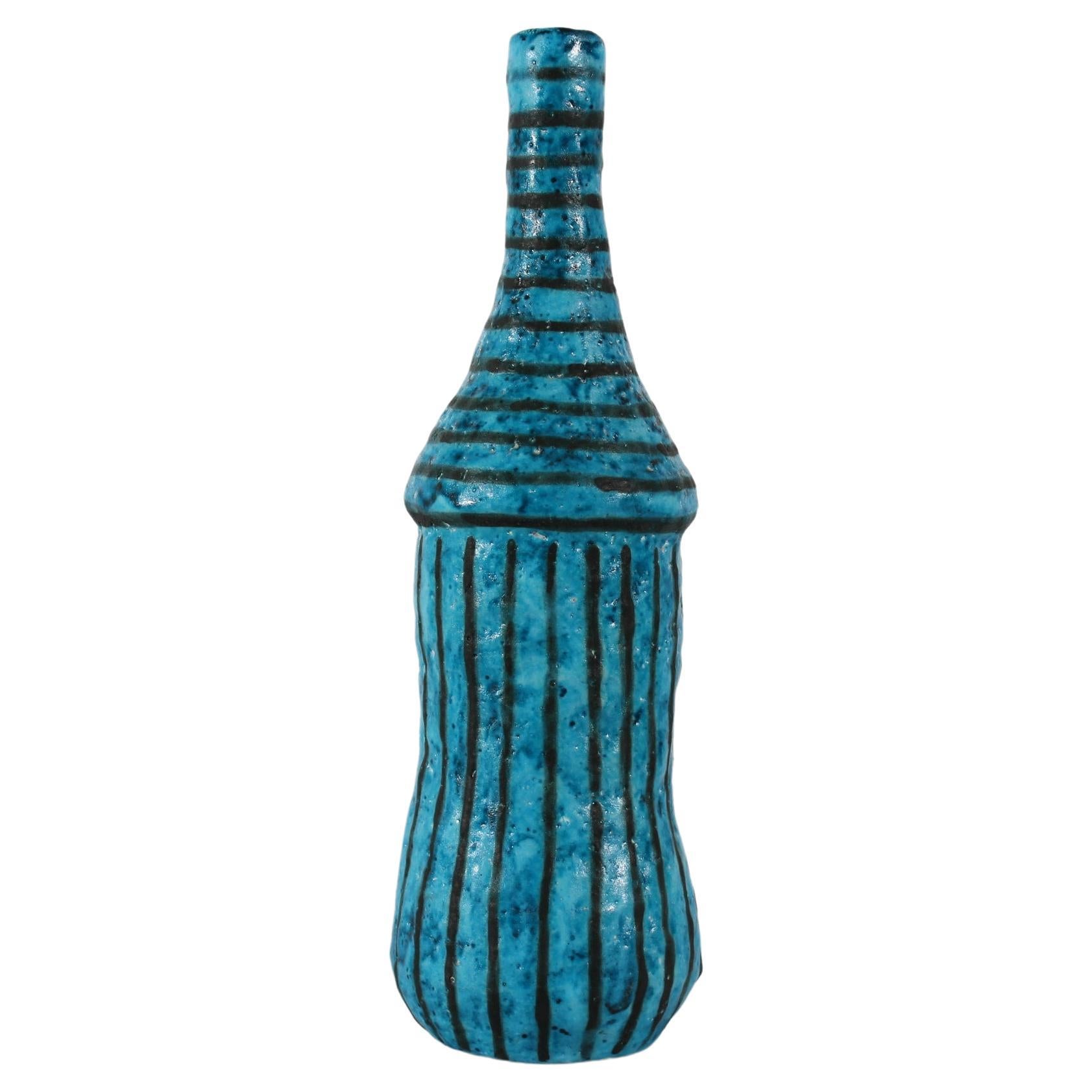 Grand et mince vase bouteille artistique du céramiste italien Guido Gambone (1909-1969), vers les années 1950.
Le vase légèrement asymétrique est décoré d'une glaçure turquoise mate avec des rayures noires.

Signé : Gambone Italie
Tampon avec un