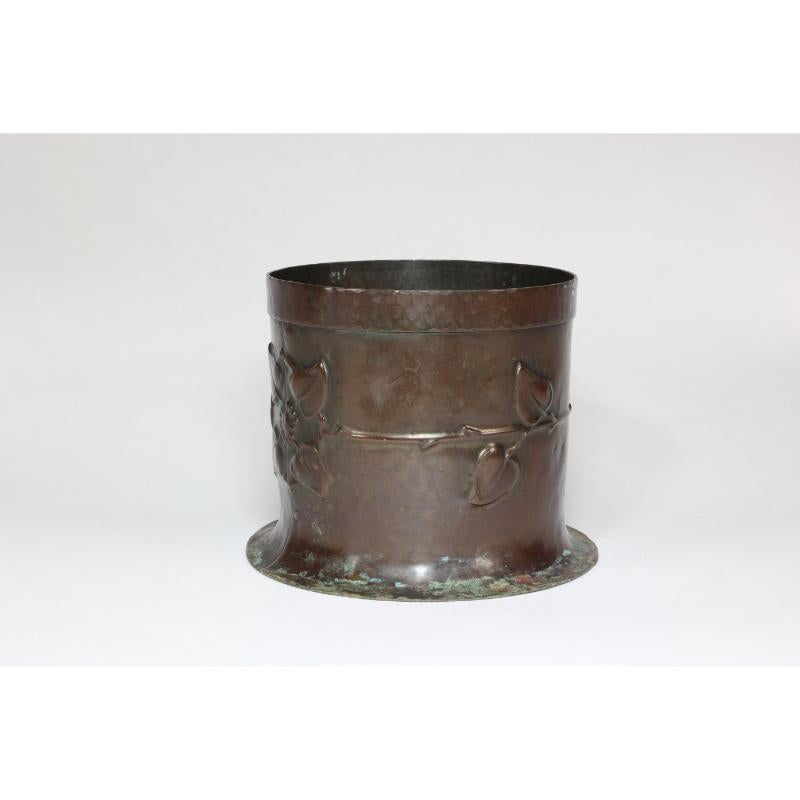 Guild of Handicraft in the style of. An Arts and Crafts copper planter with chocolate patina and hand-formed flower heads to the body.
