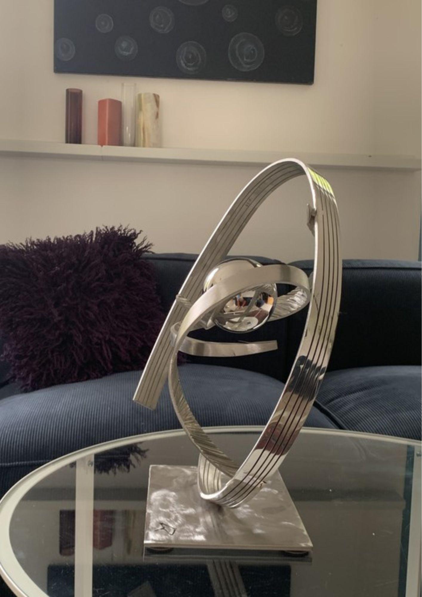 The sculpture Atomos 9 is a stainless steel work that captures the essence of matter and energy. With her fine and light curves, she explores the notions of balance and movement in a space where reality and illusion meet.

The artist is inspired by