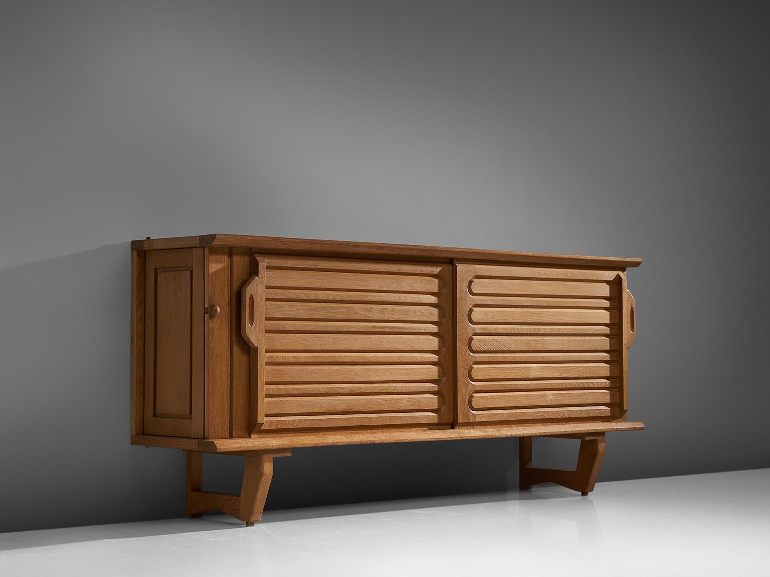 Robert Guillerme and Jacque Chambron, sideboard, oak and ceramics, France, 1960s.

This well proportioned sideboard is designed by Guillerme and Chambron and features horizontal engravings in the front sliding doors. On the sides, the cabinet