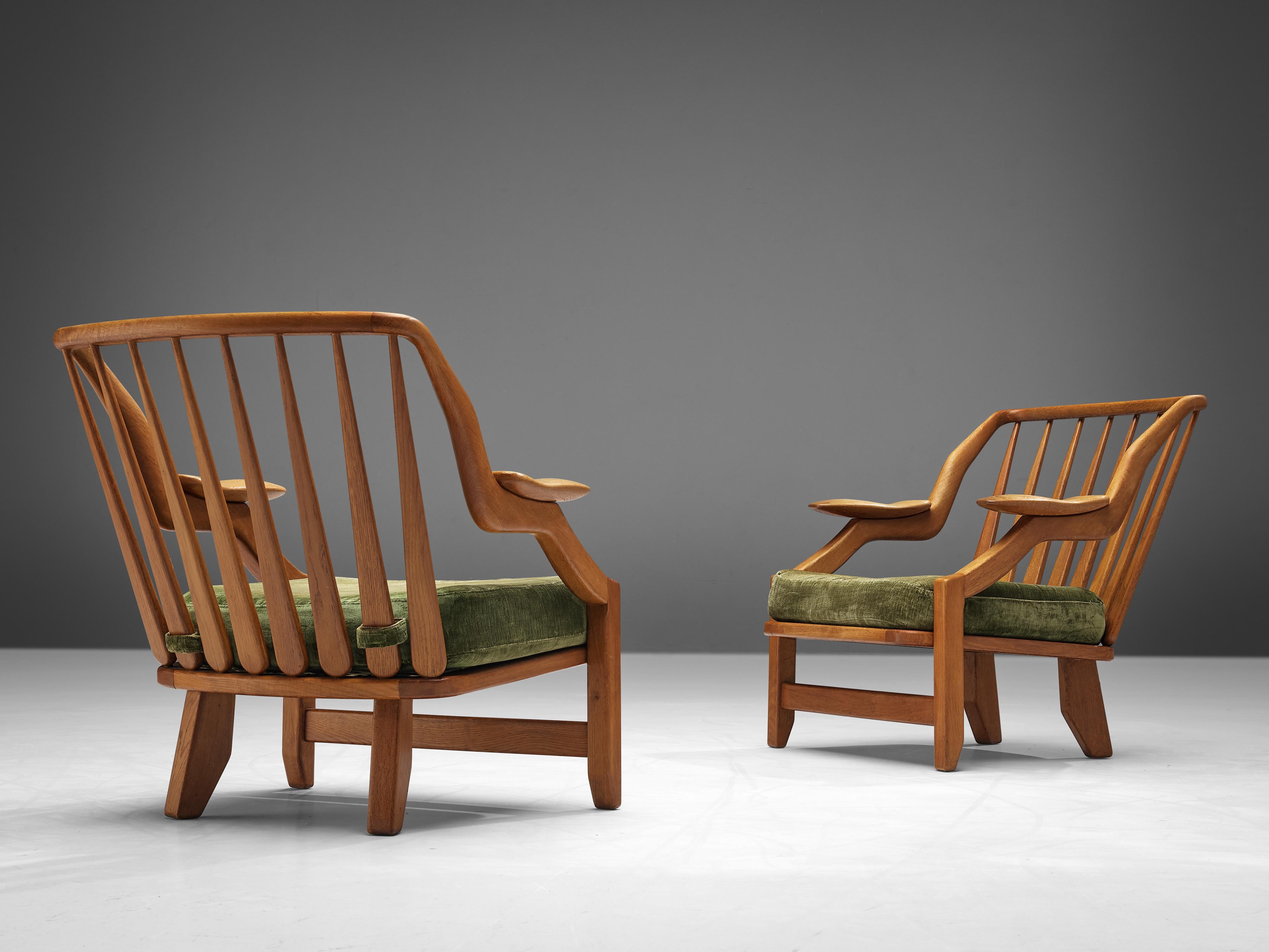 Guillerme & Chambron for Votre Maison, pair of lounge chairs model 'Gregoire', oak, velvet, France 1960s.

The French designer duo is known for their extreme high-quality solid oak furniture, from which this pair is another great example. These