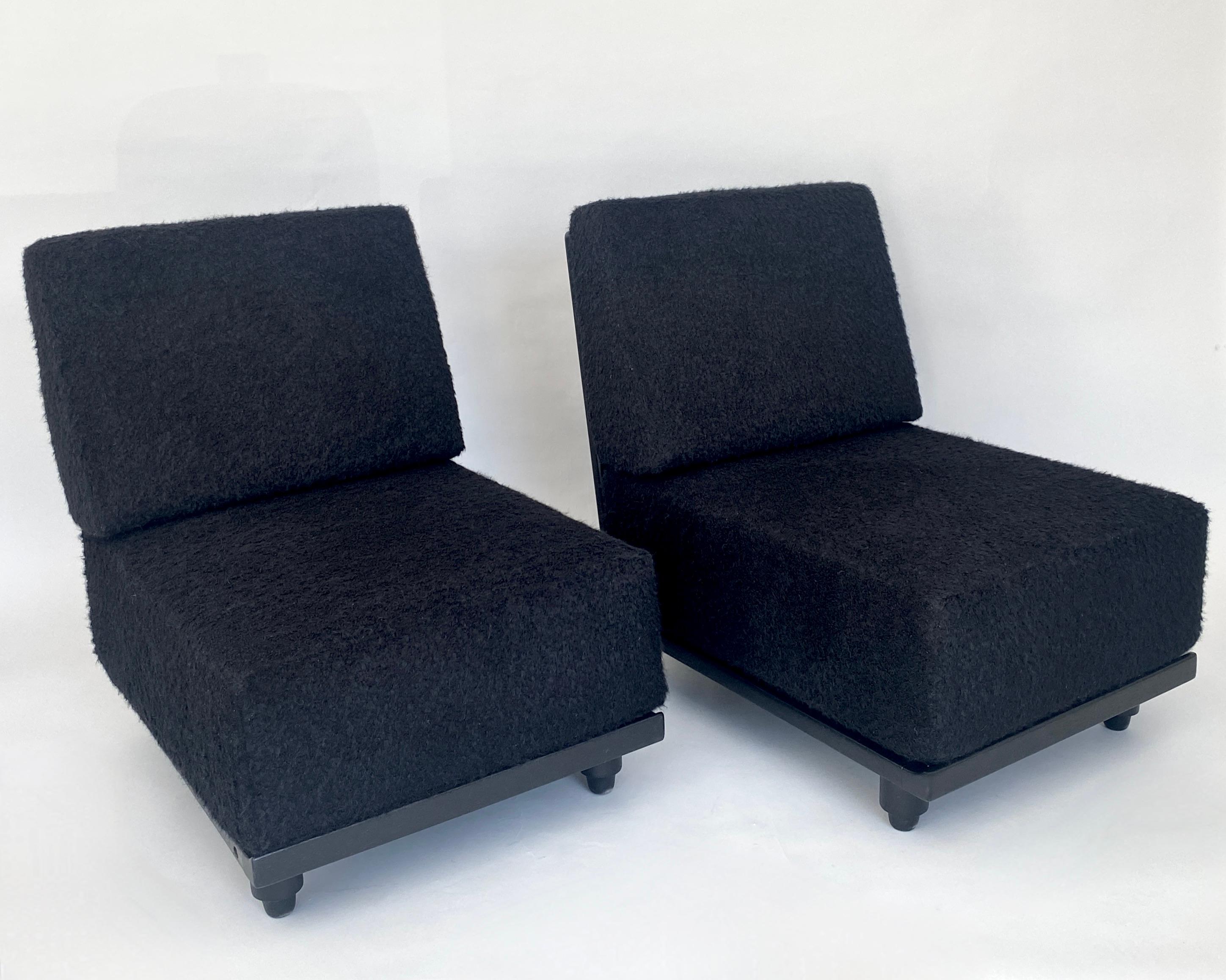 Two French Gullerme et Chambron or Guillerme and Chambron lounge chairs in ebonized French oak for Votre Maison. 
This pair of the model Elmyre lounge chairs have a very deep and thick cushion that raises the sitter off the floor as a more typical