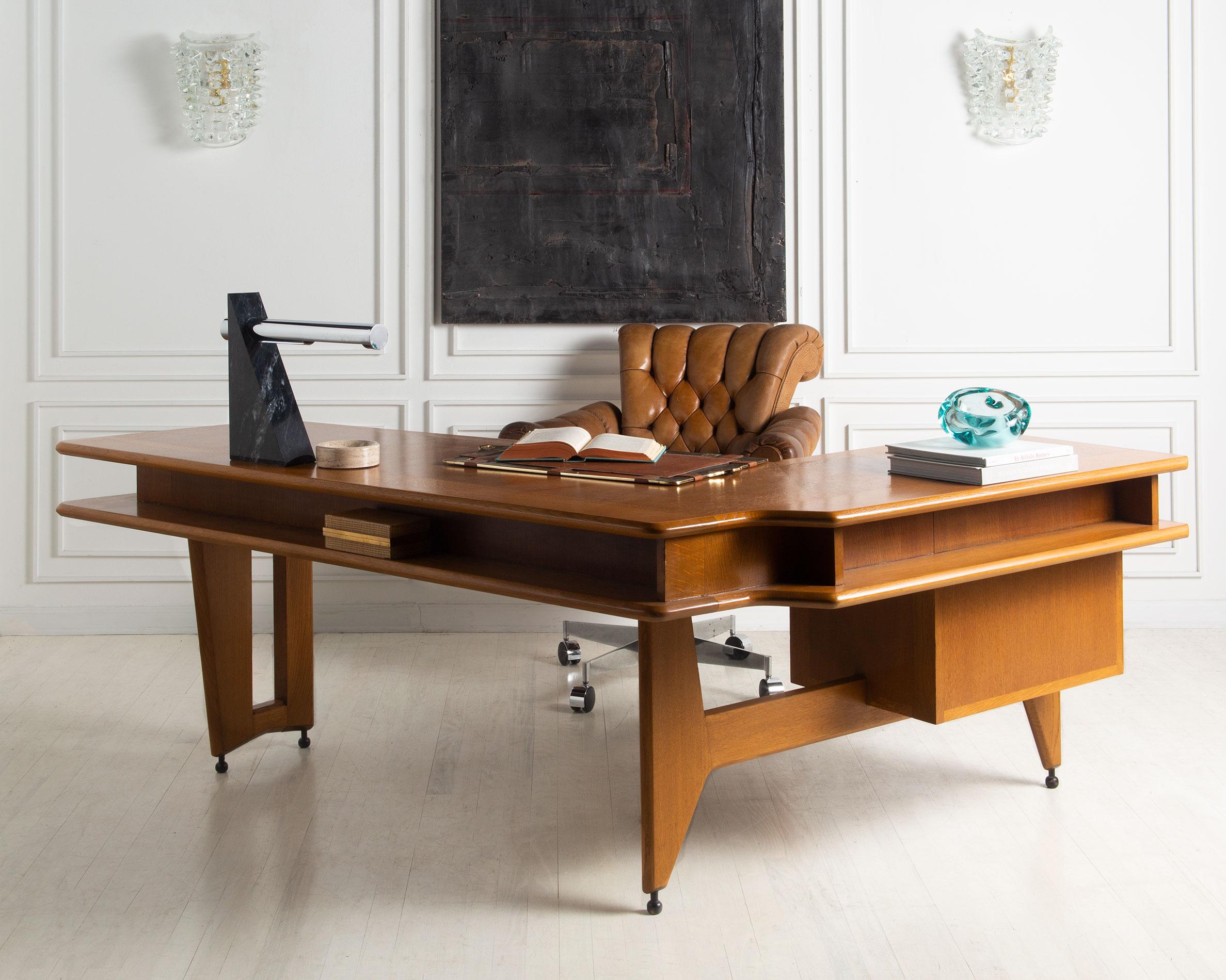 A rare desk by French design icons Guillerme and Chambron. Crafted of fine oakwood and featuring a custom ceramic pulls.

The desk has three drawers on the left hand side and a decorative shelf on the perimeter. This is a wonderful piece to have