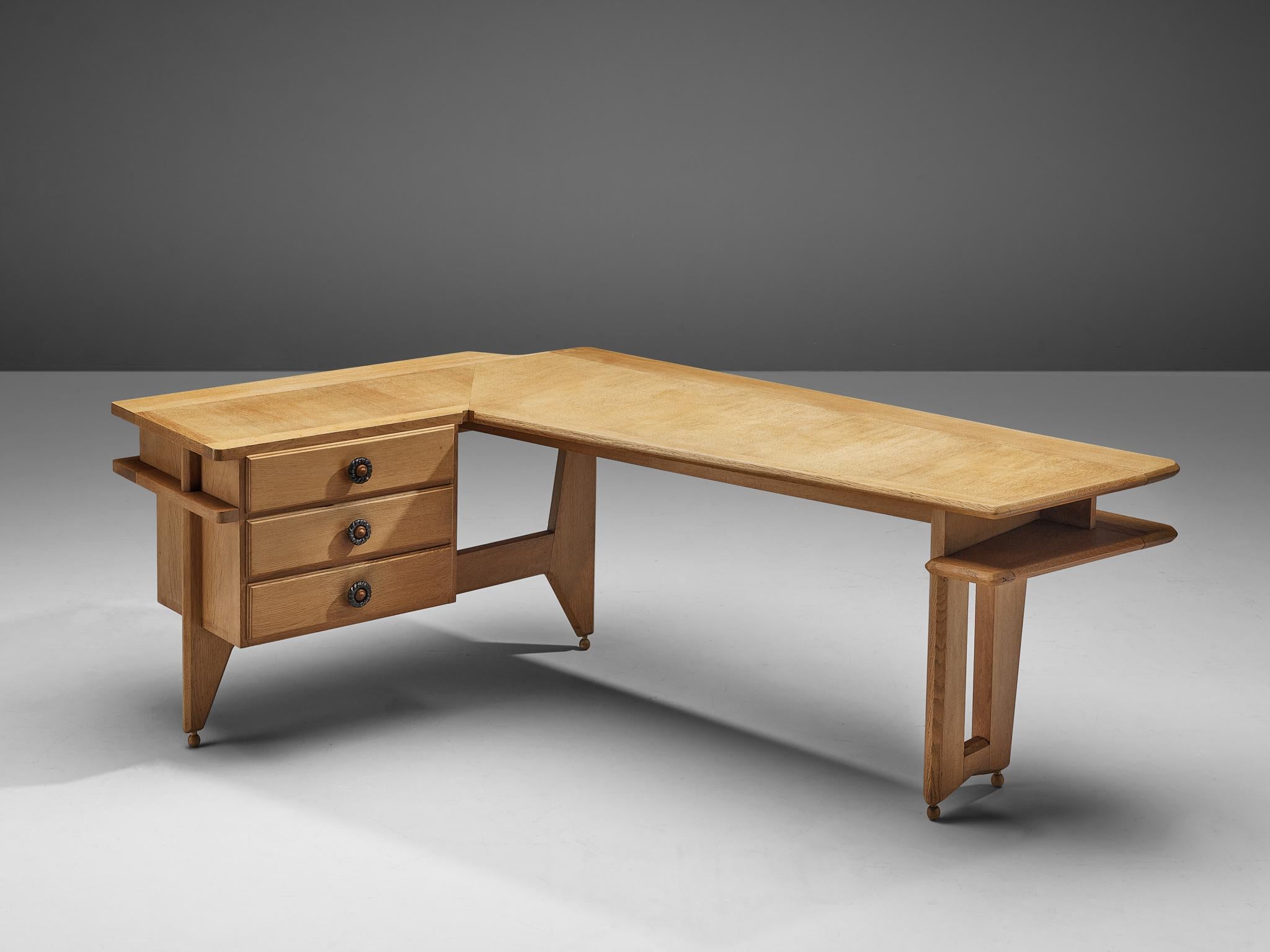 Guillerme et Chambron, corner desk in oak, France, 1960s.

This desk and return, is executed in solid oak by French designers Guillerme et Chambron. This elegant corner desk shows interesting details. First there is the shaped of the top, which is