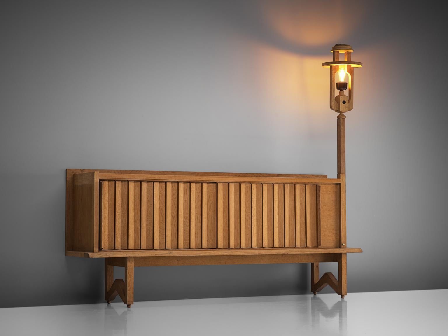 Guillerme et Chambron, credenza with lantern, solid oak and stone, France, 1960s.

This sideboard holds the characteristics of the French designer duo Guillerme & Chambron. The base has typical legs and provides a floating appearance to the