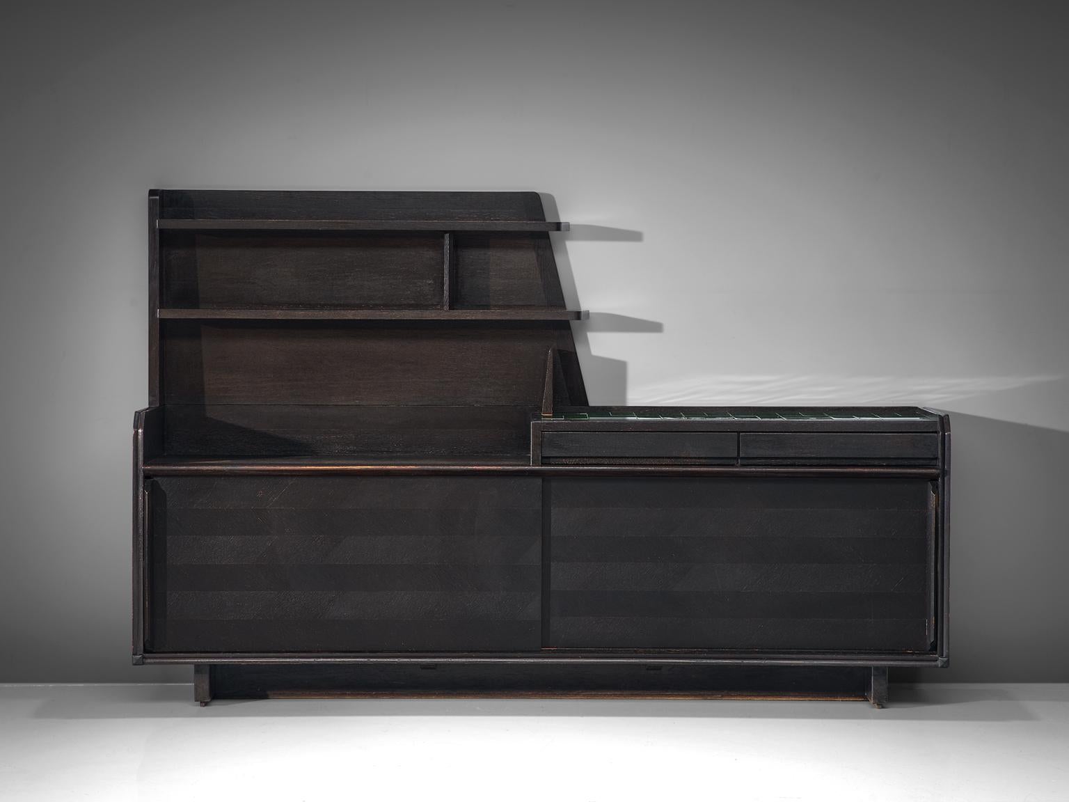 Sideboard, in oak and ceramic by Guillerme et Chambron, France, 1960s.

Large sideboards in dark stained oak. The top shows some nice green glazed tiles. Two sliding doors on the front with beautiful graphical patterns of woodcarving. The shelves