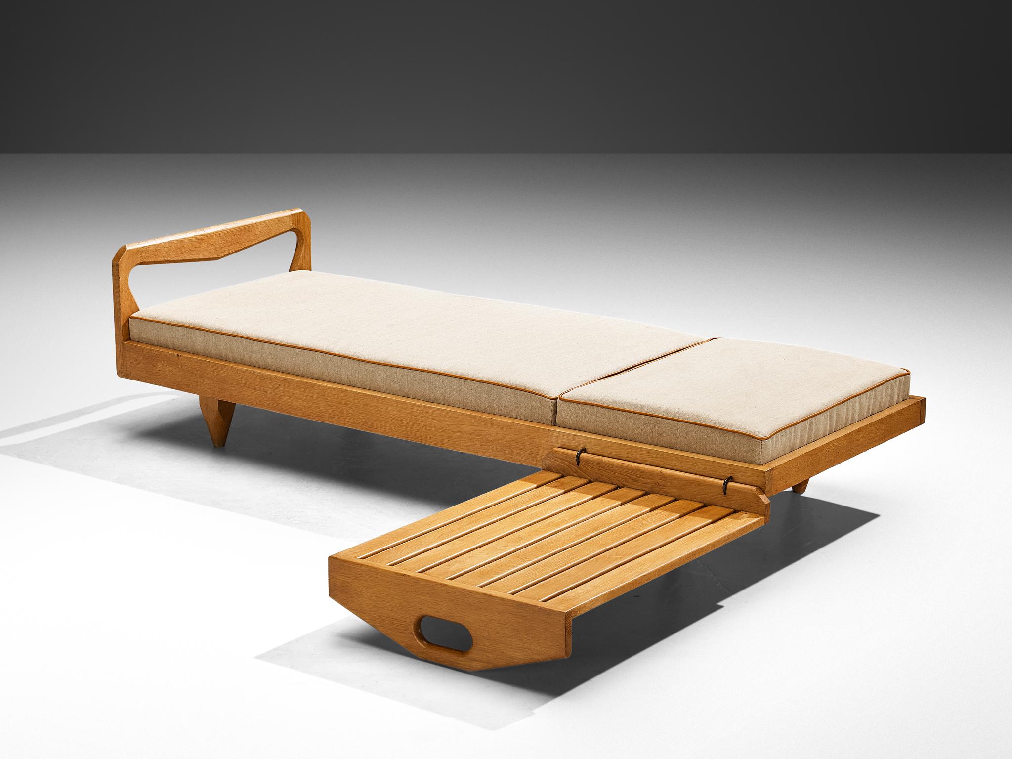 Guillerme et Chambron, daybed bench, oak, fabric, France, 1960s.

This low bench or daybed shows the admirable, characteristic details of the French designer duo Guillerme and Chambron. The bench stands on four triangular legs. The seat is made of