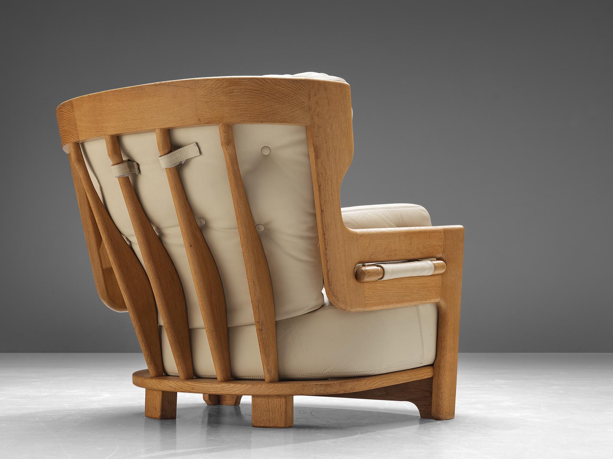 Guillerme et Chambron for Votre Maison, lounge chair 'Denis', leather, oak, France, 1960s 

Extraordinary Guillerme and Chambron lounge chair in solid oak with the typical characteristic decorative details at the back and capricious forms of the