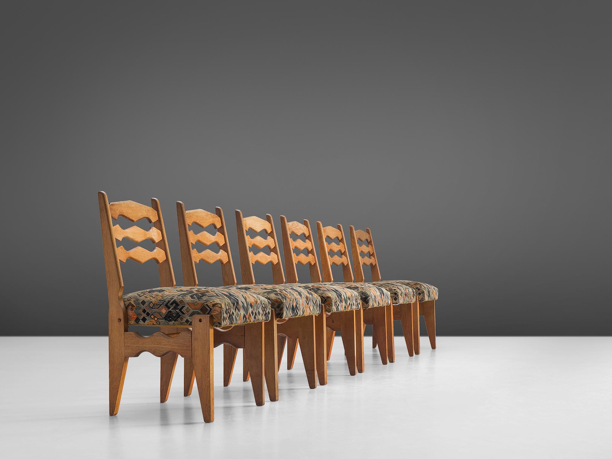 Set of six dining chairs, in oak and patterned fabric, by Guillerme & Chambron, France, 1960s.

Set of six sturdy, decorative dining chairs in solid oak by Guillerme and Chambron. These chairs show a few characteristics of this French designer