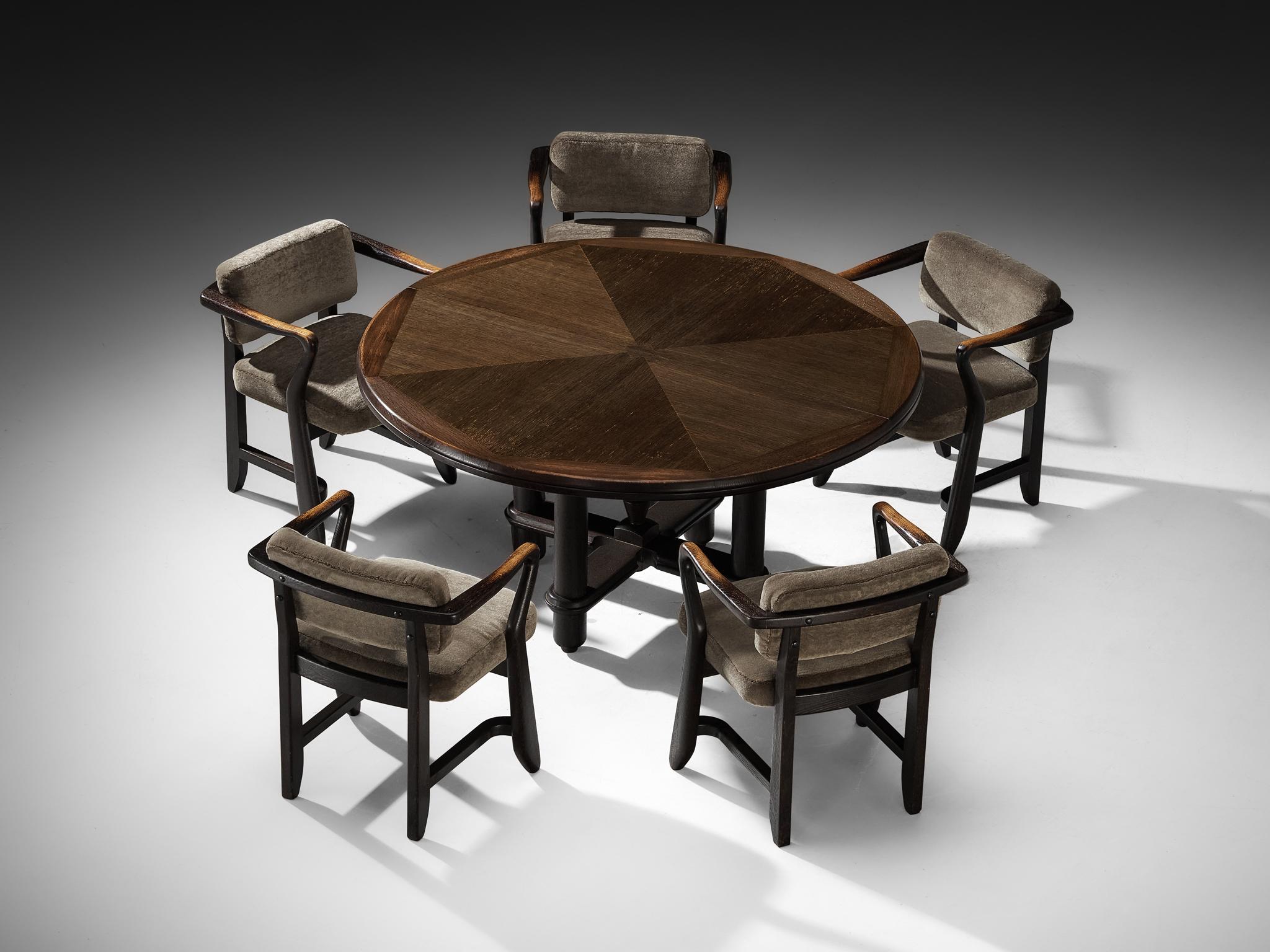 Lovely dining set designed by Guillerme & Chambron for Votre Maison

Guillerme et Chambron for Votre Maison, extendable round dining table, stained oak, France, 1960s

This dining table, crafted from stained oak, is the work of renowned French