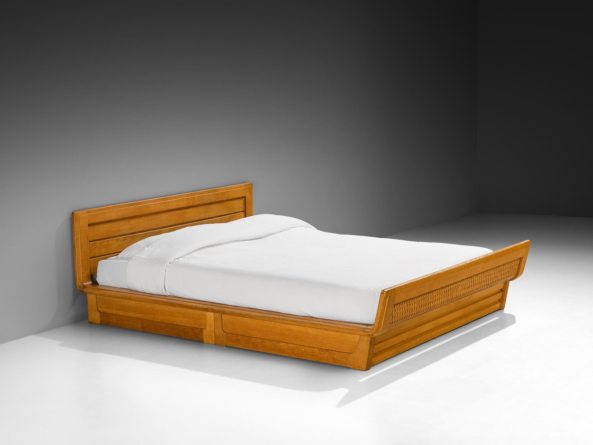 Guillerme & Chambron for Votre Maison, double bed, solid oak, France, 1960s

The standout feature of this bed is immediately apparent: the exceptional craftsmanship of the woodwork. The solid oak frame is masterfully constructed, with intricate