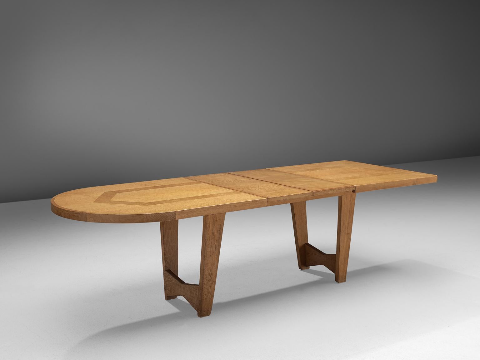 Guillerme et Chambron for Votre Maison, dining table, oak, France, 1960s.

This extendable dining table, designed by Guillerme et Chambron, features one rounded side and two extra leaves. The table to is inlayed with a subtle pattern made of