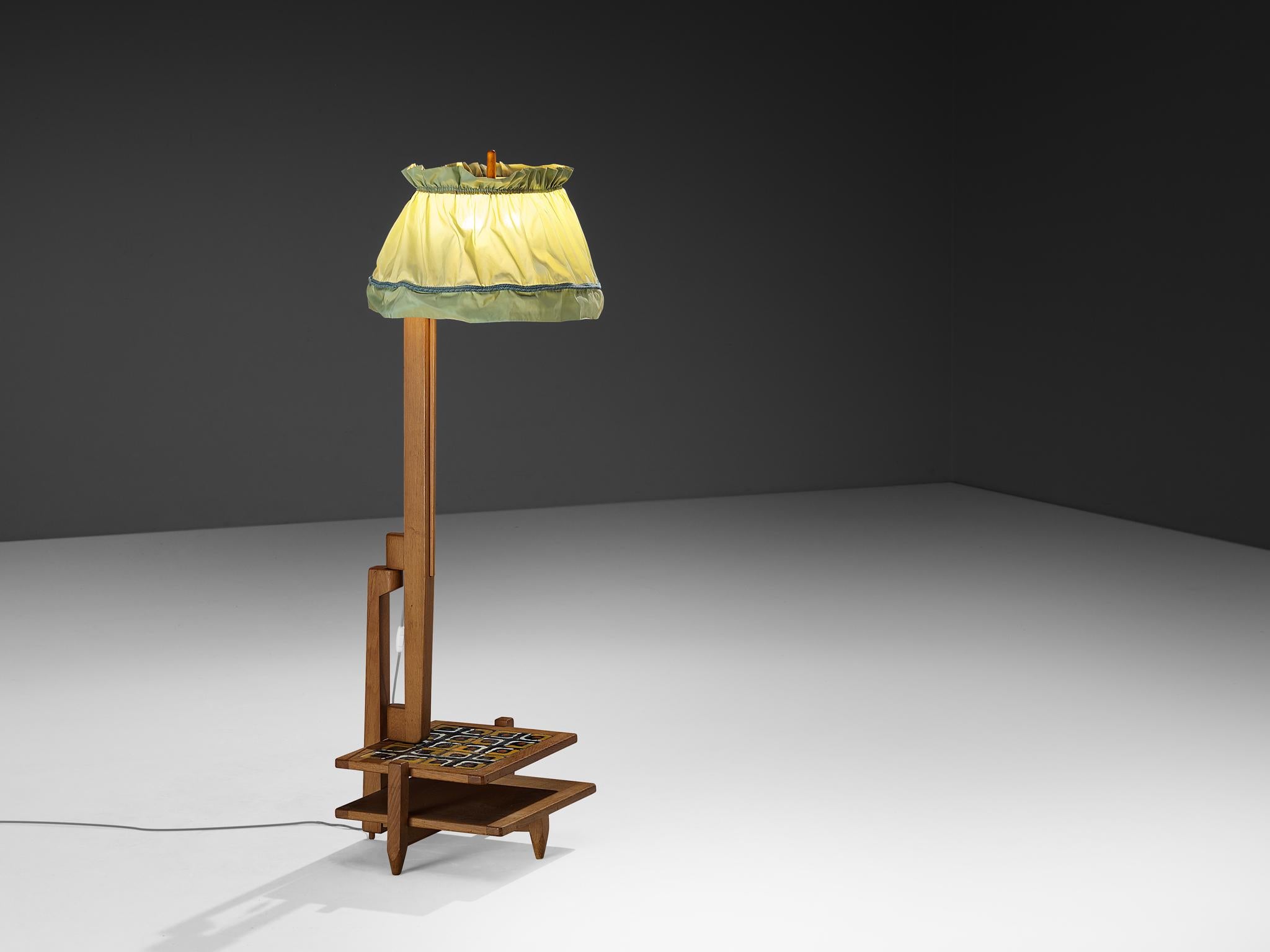 Guillerme et Chambron pour Votre Maison, lampadaire, chêne, tissu, céramique, 1970

Ce lampadaire avec table d'appoint ou étagères intégrées, conçu par les designers Guillerme et Chambron dans les années 1970, dégage un charme rustique. La forme et