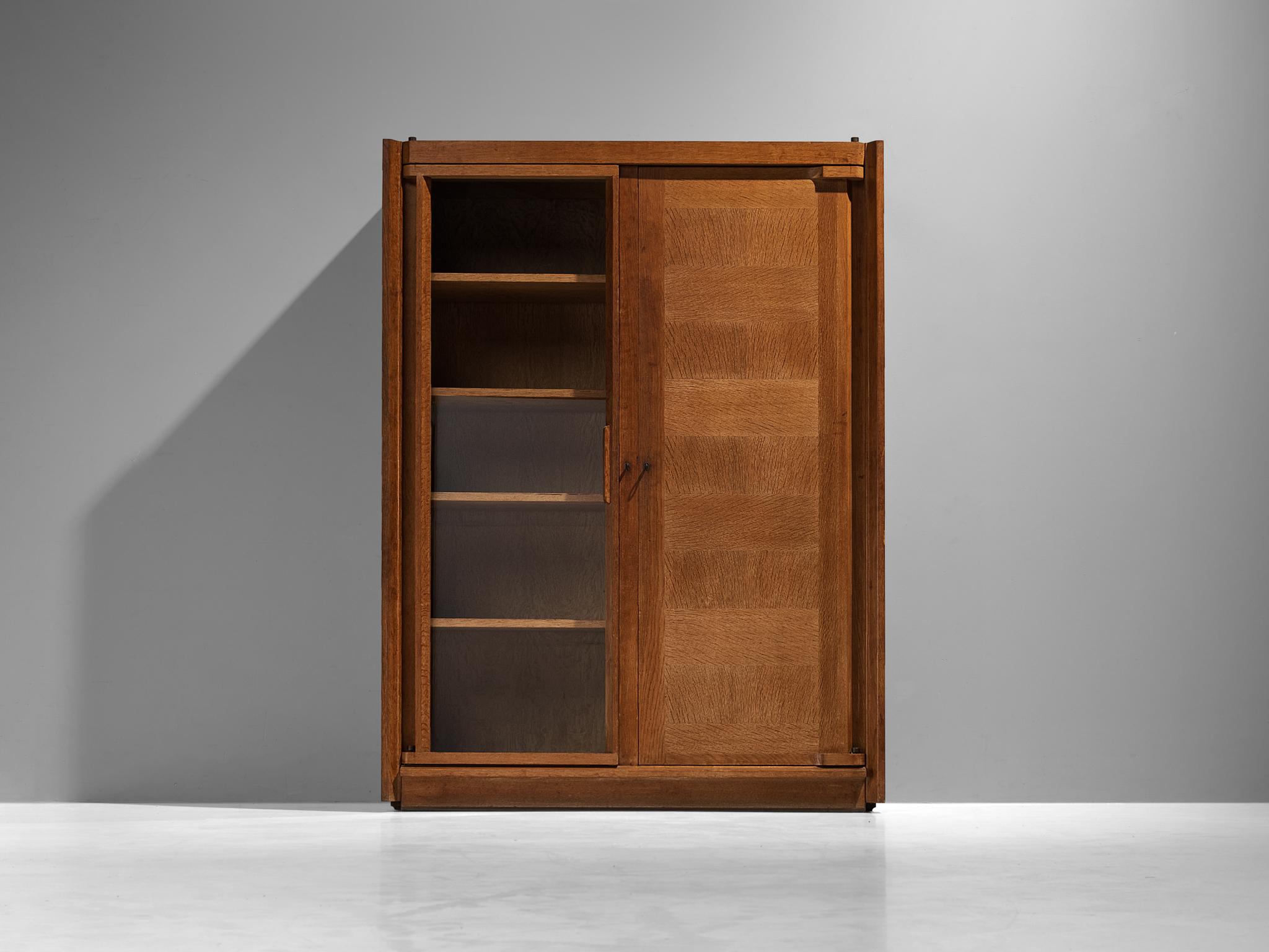 Guillerme et Chambron, large cabinet or wardrobe, oak, glass, France, 1960s

This case piece is designed by Guillerme and Chambron and features geometric oak inlays, creating horizontal panels on the front of the cabinet, which is a design