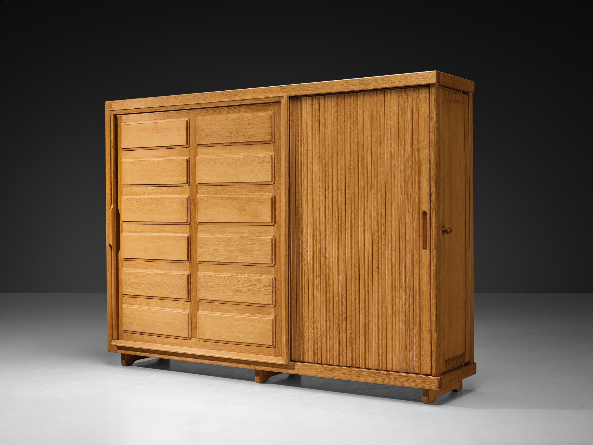 Guillerme et Chambron für Votre maison, Kleiderschrank, Eiche, Frankreich, 1960er Jahre

Dieser grandiose Schrank ist ein gutes Beispiel für exzellente Holzverarbeitung. Die grafisch gestalteten Türpaneele zeigen langgestreckte, vertikale Linien und