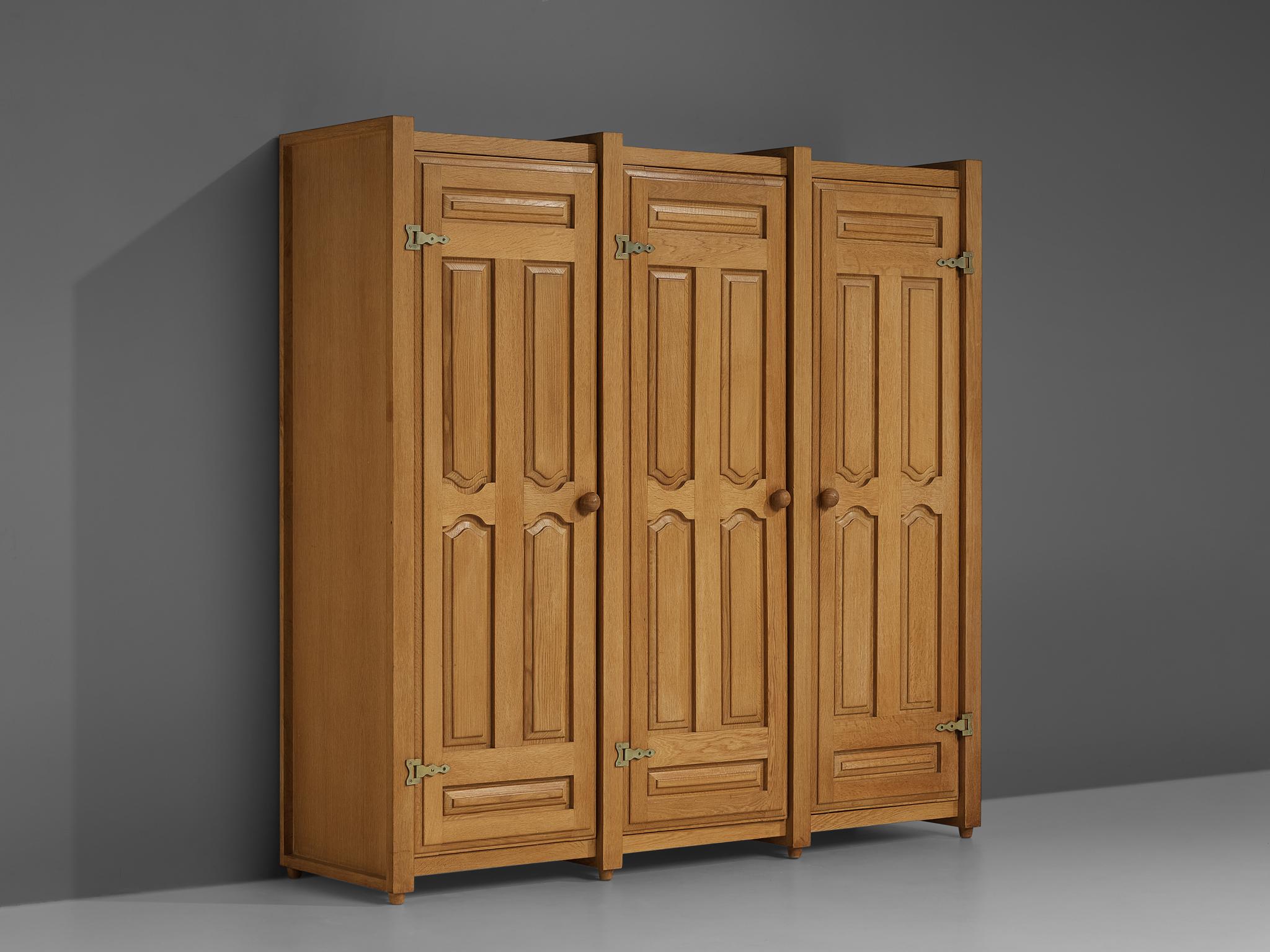 Guillerme et Chambron for Votre Maison, armoire, oak, brass, France, 1960s.

This wardrobe is designed by Guillerme and Chambron and features geometric carvings in the doors which is typical for the French duo. The armoire offers plenty of storage