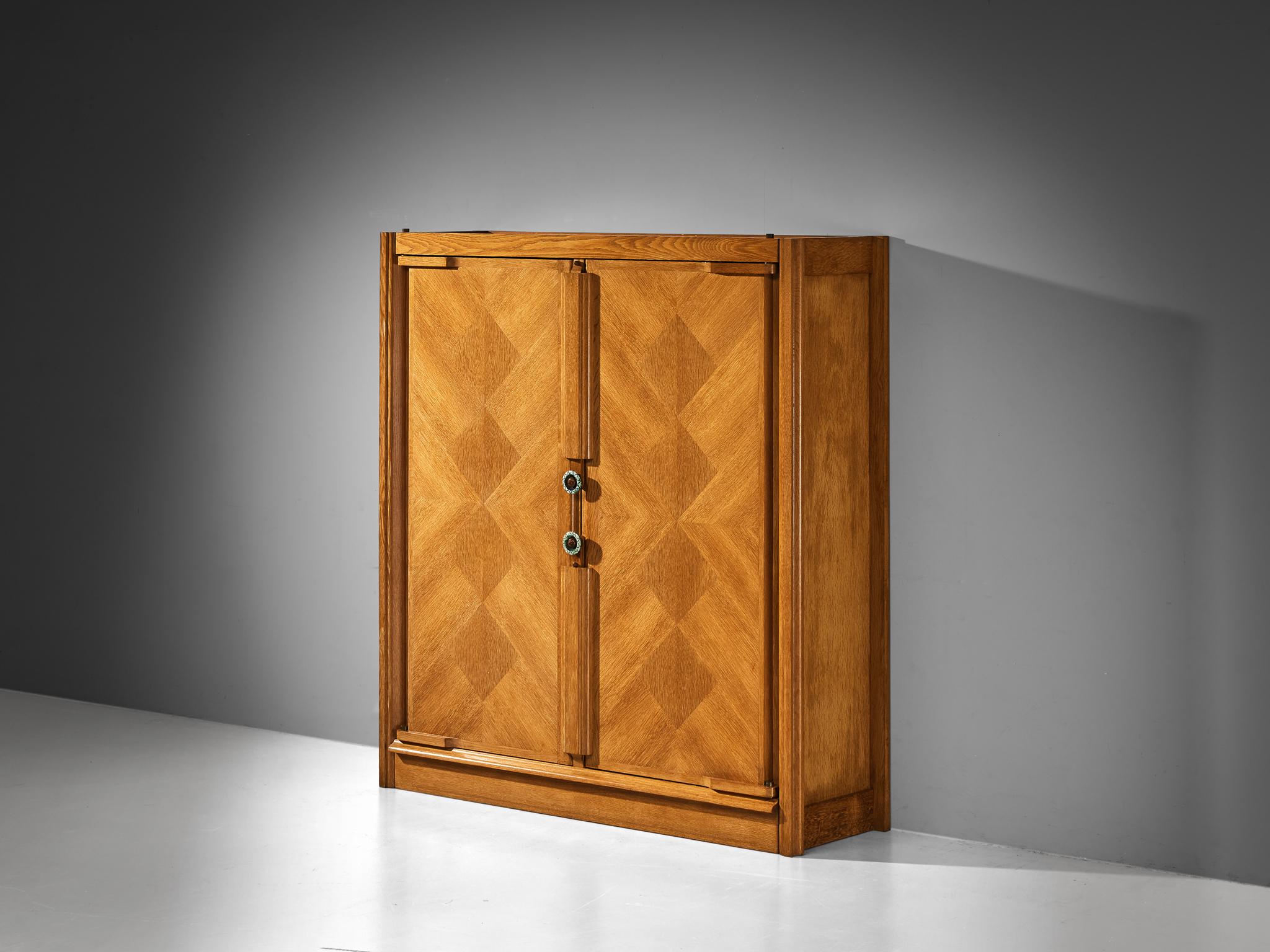 Guillerme et Chambron, highboard or cabinet, oak, ceramic, France, 1960s

This wardrobe is based on a well-designed structure where aesthetics and functionally go hand in hand. The door panels have the characteristics of the French designer duo