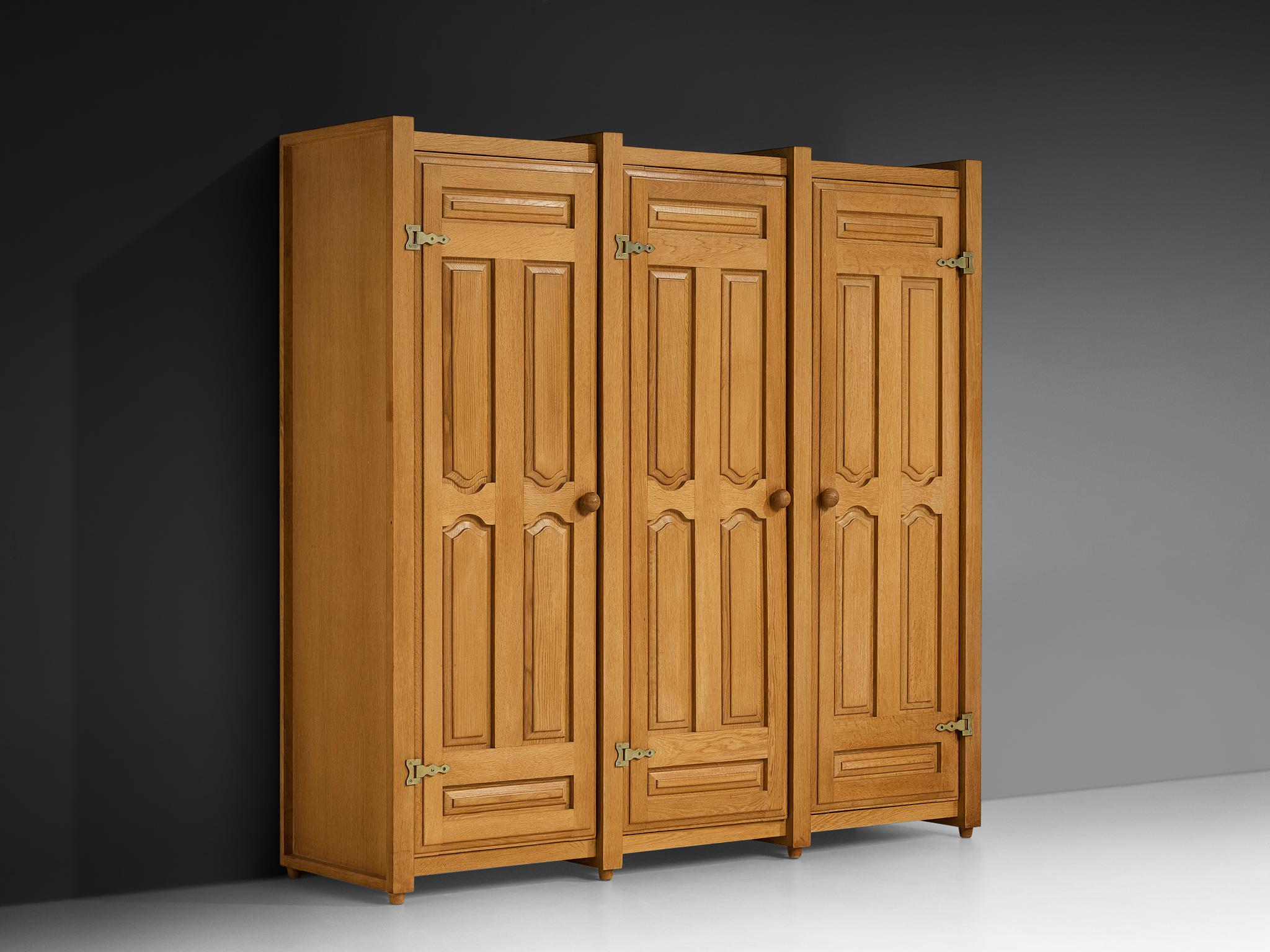 Guillerme et Chambron pour Votre Maison, armoire, chêne, laiton, France, années 1960.

Cette armoire a été conçue par Guillerme et Chambron et présente des sculptures géométriques dans les portes, ce qui est typique du duo français. L'armoire offre