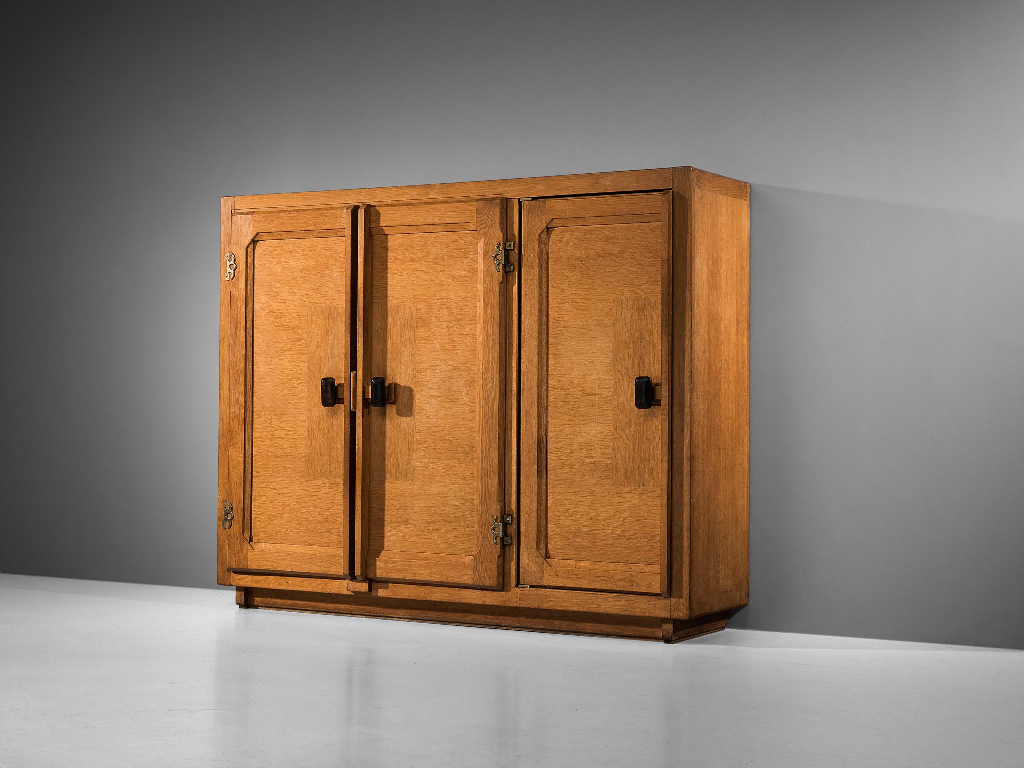 Guillerme et Chambron for Votre Maison, armoire, oak, brass, France, 1960s

This grandiose wardrobe is a good example of excellent woodworking by virtue of the inlay veneer and the graphic designed door panels, creating a rhythmic pattern on the