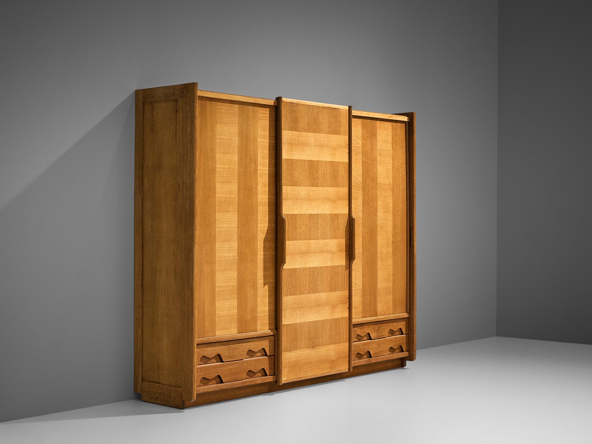 Guillerme et Chambron for Votre Maison, wardrobe, oak, France, 1960s.

This grandiose wardrobe is a good example of excellent woodworking by virtue of the inlay veneer and the graphic designed door panels, creating a rhythmic pattern to the front.