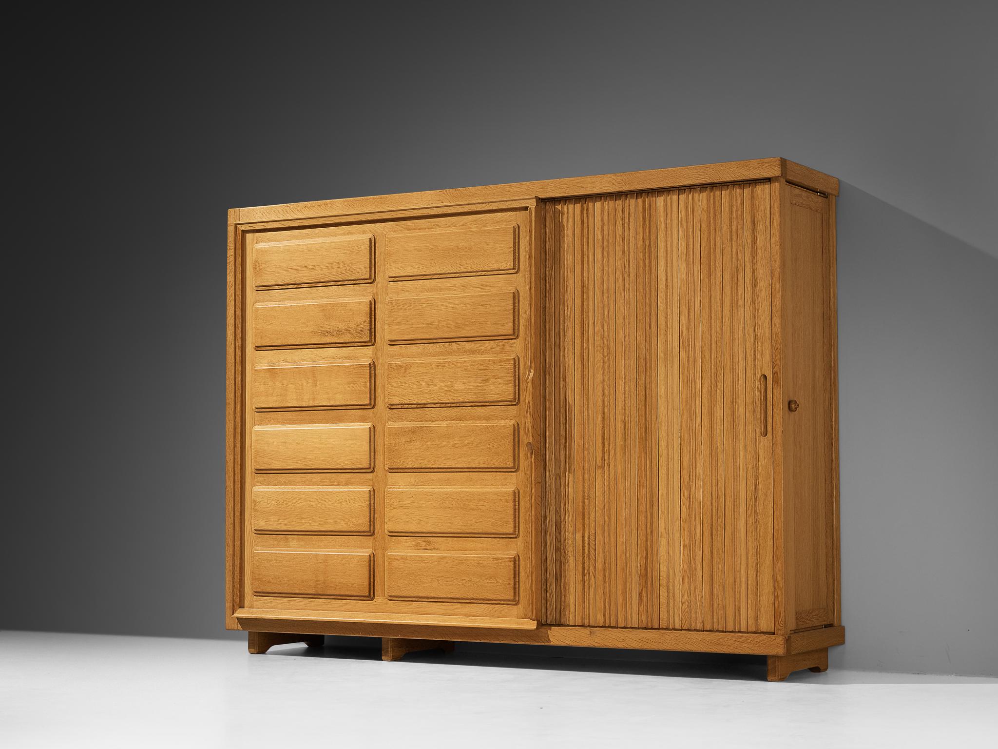 Guillerme et Chambron for Votre maison, armoire, oak, France, 1960s

This striking wardrobe exemplifies fine woodworking, highlighted by the graphically designed door panels with elongated vertical lines and geometric carvings that form a rhythmic