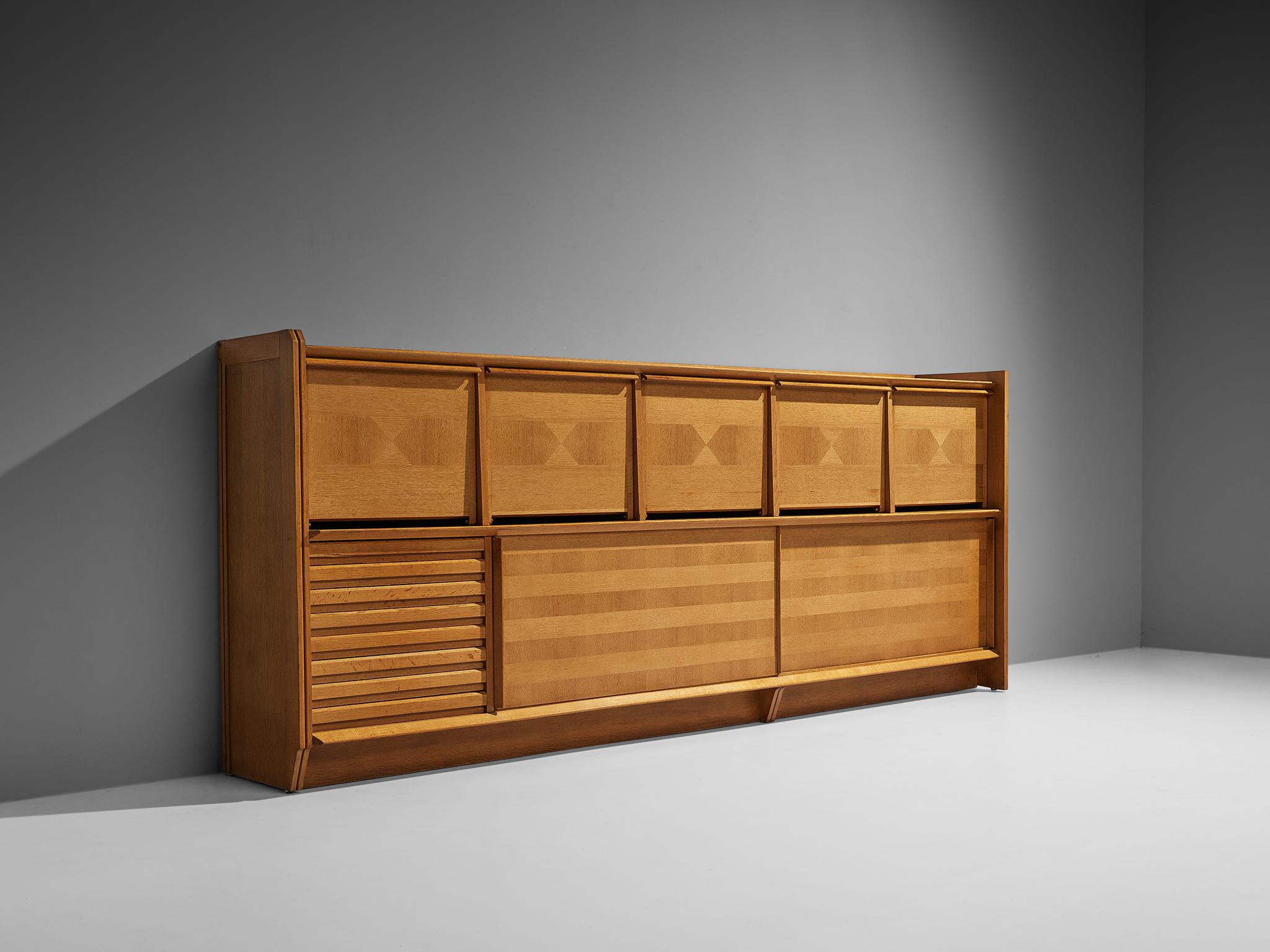 Guillerme et Chambron for Votre Maison, large sideboard, oak, France, 1960s. 

This exceptionally large storage unit designed by French designer duo Guillerme et Chambron is truly something you cannot easily overlook. With its width of 11.8 feet,