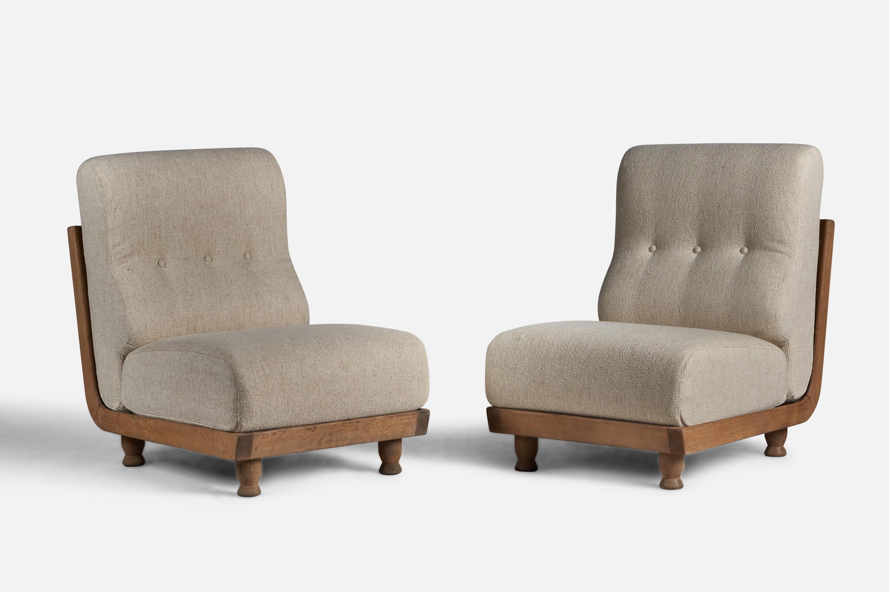 A pair of beige fabric and oak lounge or slipper chairs designed by Robert Guillerme and Jacques Chambron, France, 1950s.

16.5” seat height