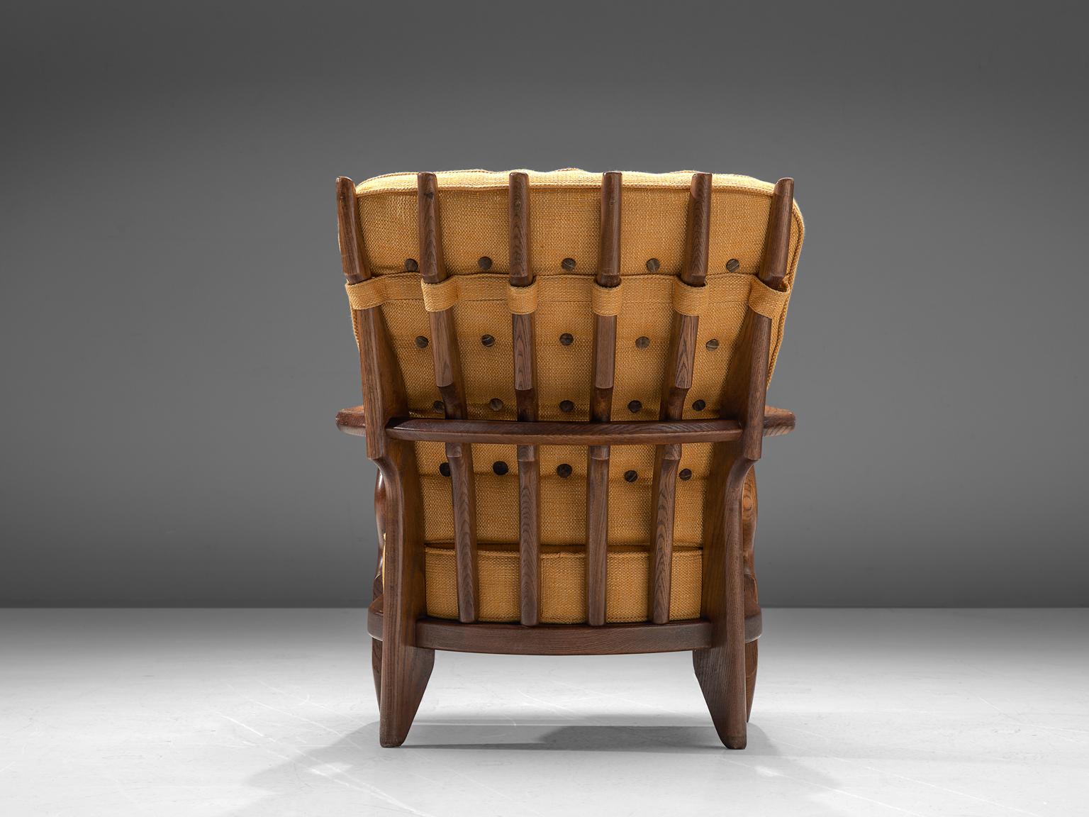 Guillerme et Chambron, lounge chair, oak and yellow upholstery, France, 1960s. 

Well sculpted Guillerme and Chambron 'Mid Repos' lounge chair, in solid oak with the typical characteristic decorative details at the back and capricious forms of the