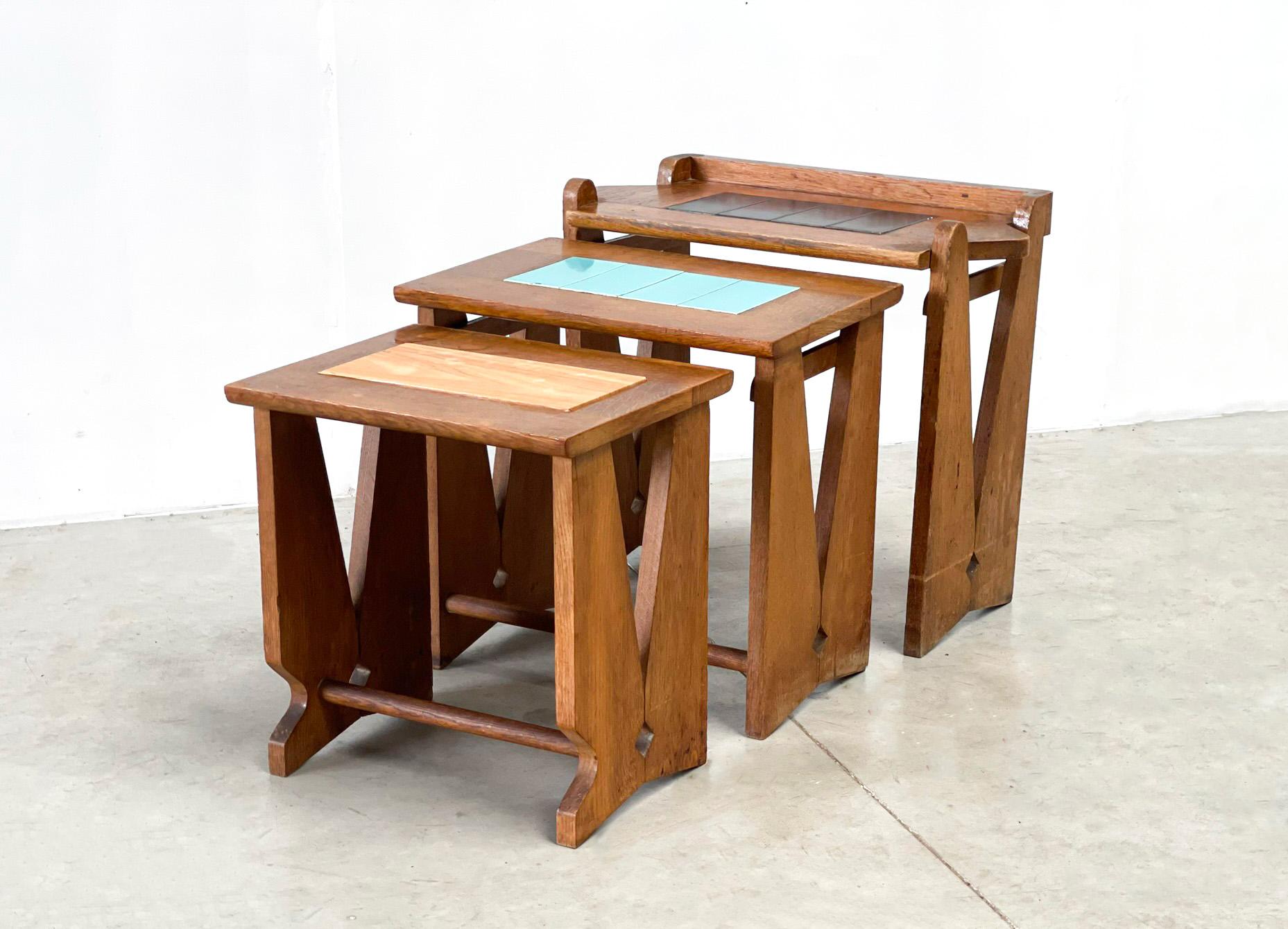 3 French nesting tables made by famous designers Guillerme & Chambron. The tables are from the 70s from france. They have an oak frame and a ceramic tile on top. Only one of them has a piece of wood with veneer.Guillerme & Chambron are best known