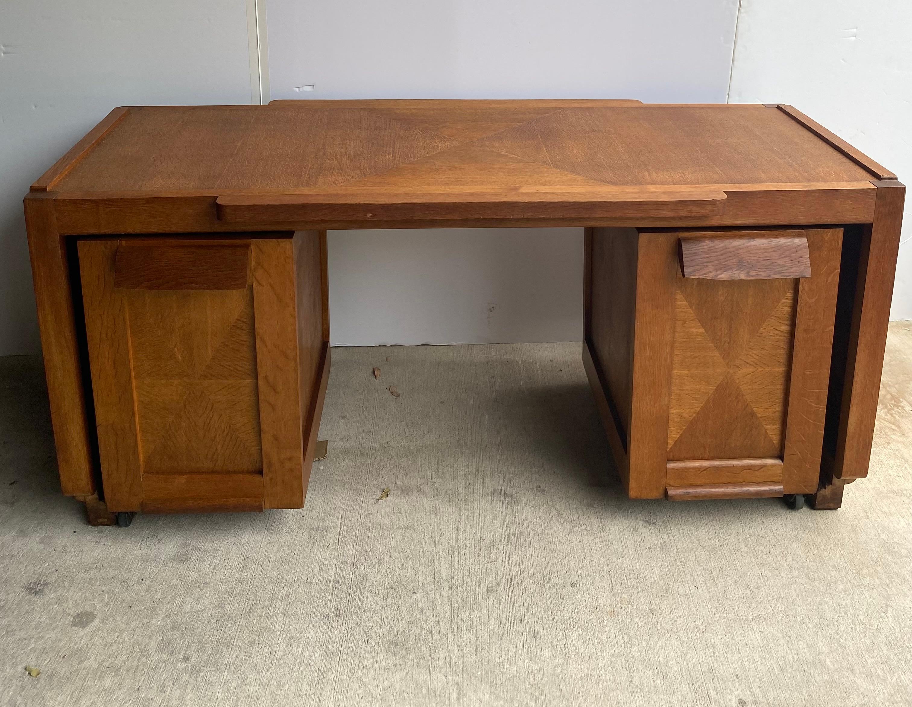 Desk by collectible Mid-Century Modern designers Guillerme et Chambron in their Classic French oak with inlay pattern. This set includes the waterfall desk with two independent file storage cabinets that roll beneath it on discreet wheels. France,