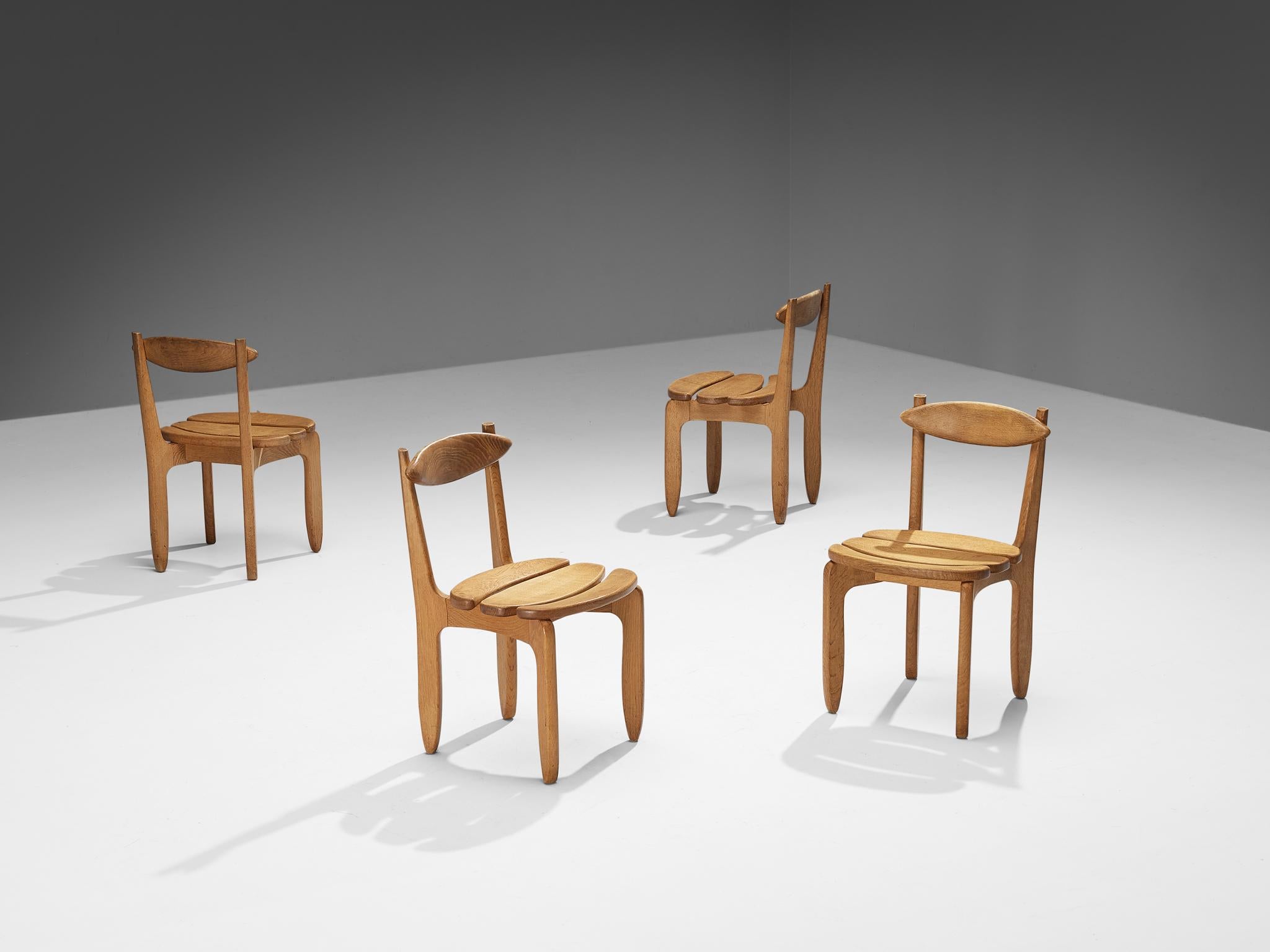 Guillerme et Chambron for Votre Maison, set of four 'Thierry' dining chairs, oak, France, 1960s.

Set of four elegant and robust dining chairs in solid oak by Guillerme and Chambron. These chairs show the characteristic frame of this French designer