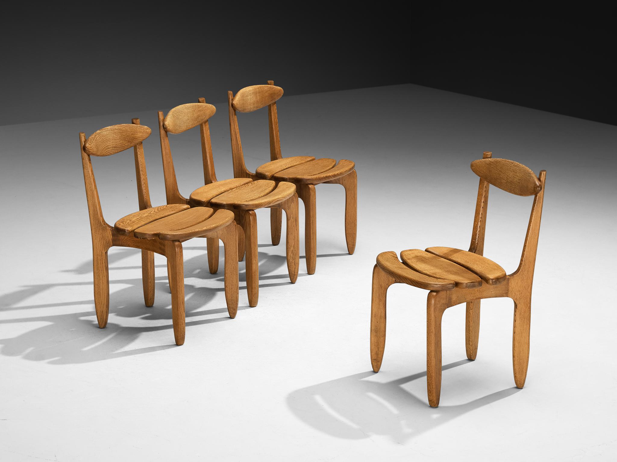 Guillerme et Chambron for Votre Maison, set of four 'Thierry' dining chairs, oak, France, 1960s.

Set of four elegant and robust dining chairs in solid oak by Guillerme and Chambron. These chairs show the characteristic frame of this French designer