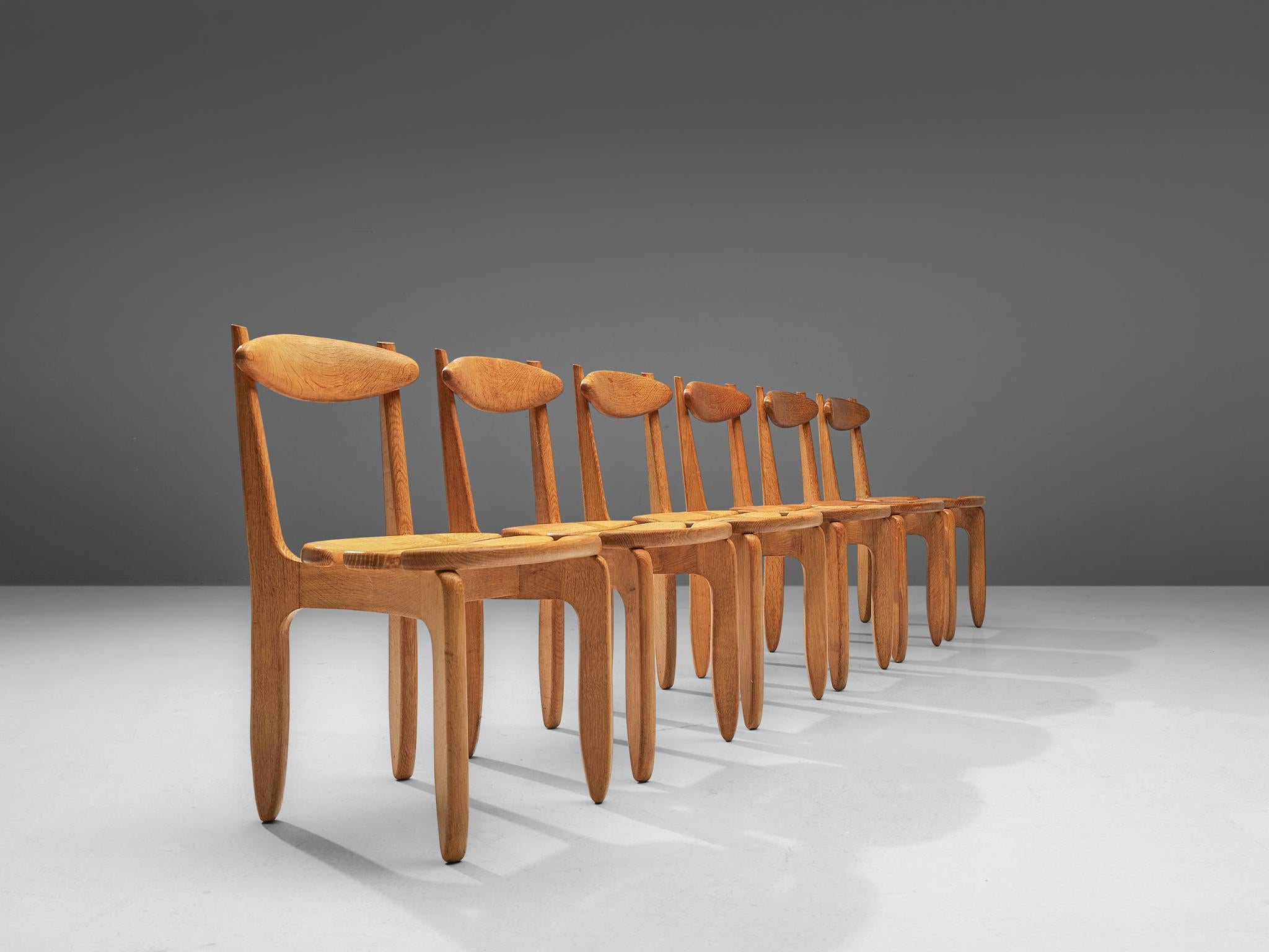 Guillerme et Chambron for Votre Maison, set of six dining chairs, oak, France, 1960s.

Set of six elegant and robust dining chairs in solid oak by Guillerme and Chambron. These chairs show the characteristic frame of this French designer duo,